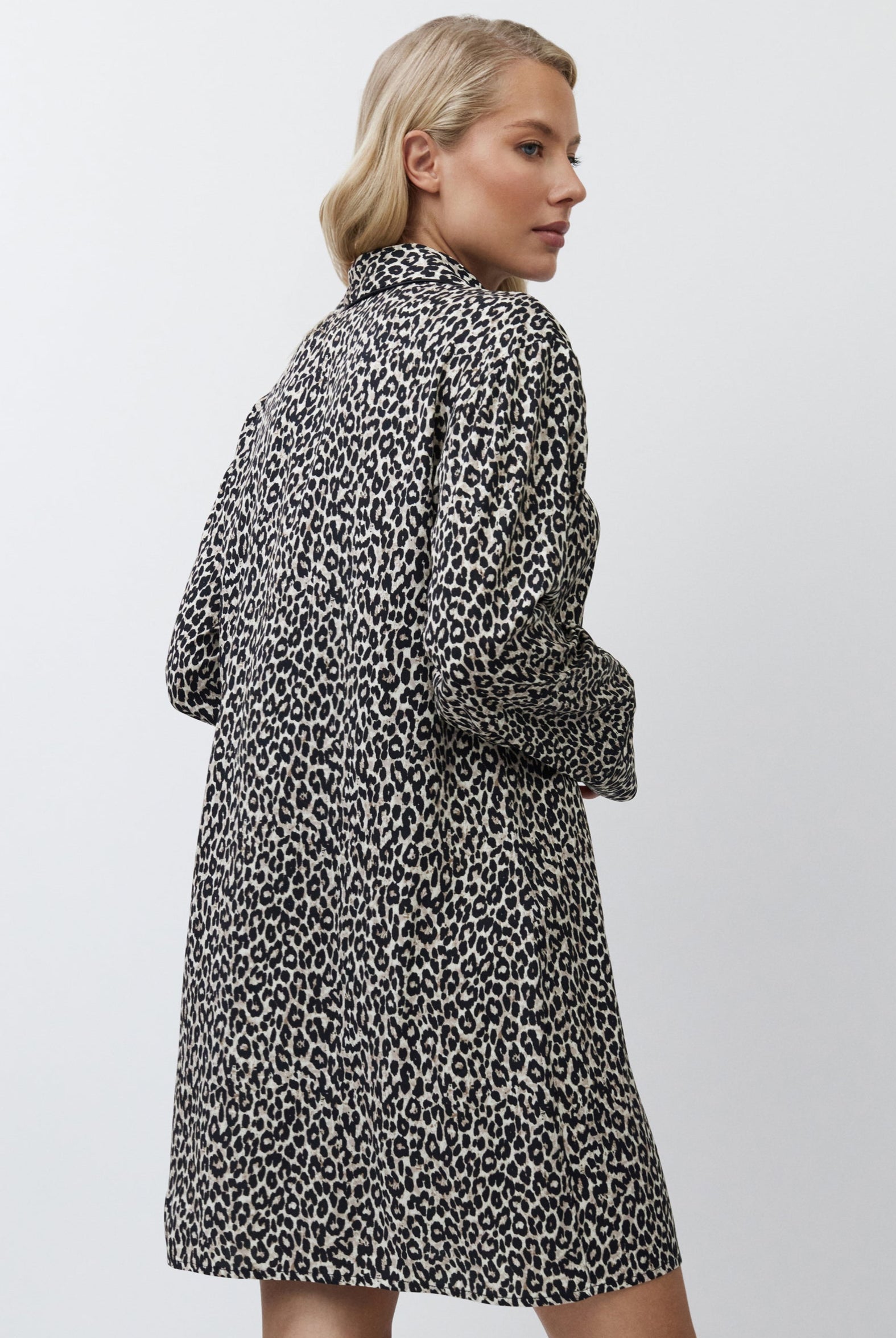 Woman wearing a patterned nightdress on a plain background