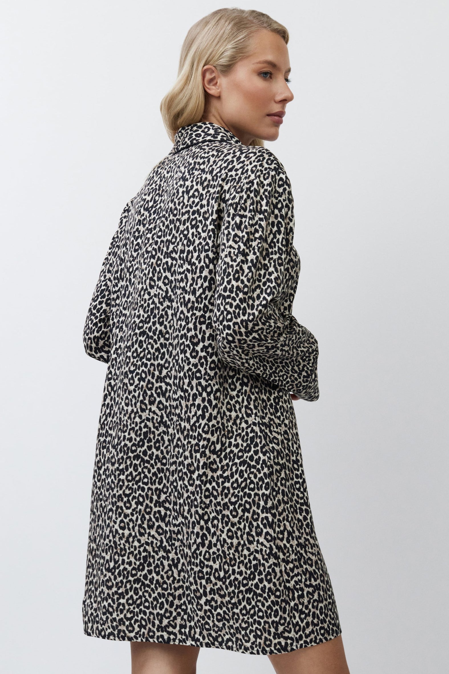 Woman wearing a patterned nightdress on a plain background