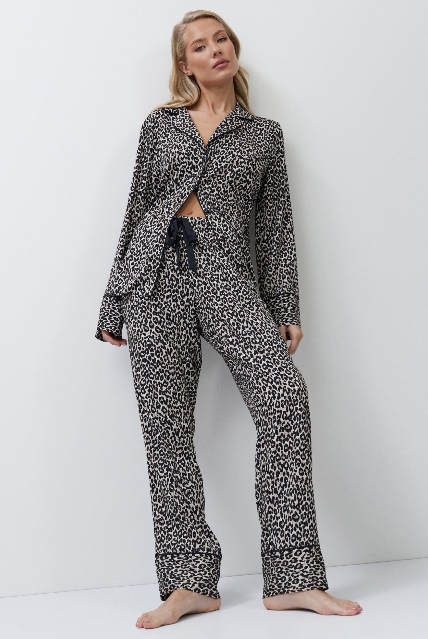 Woman wearing a leopard patterned pajama set on a white background