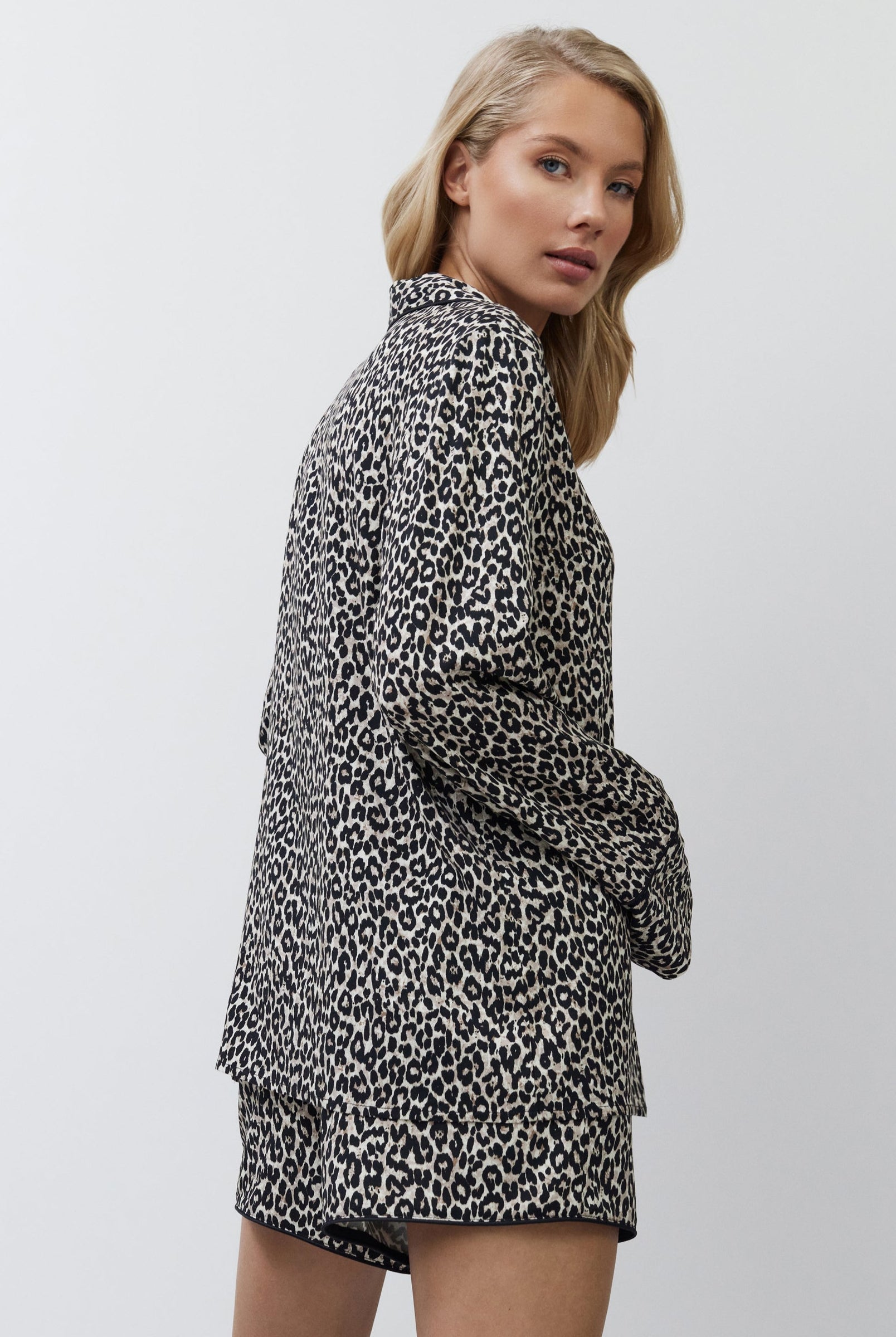 Woman wearing a leopard print outfit on a plain background
