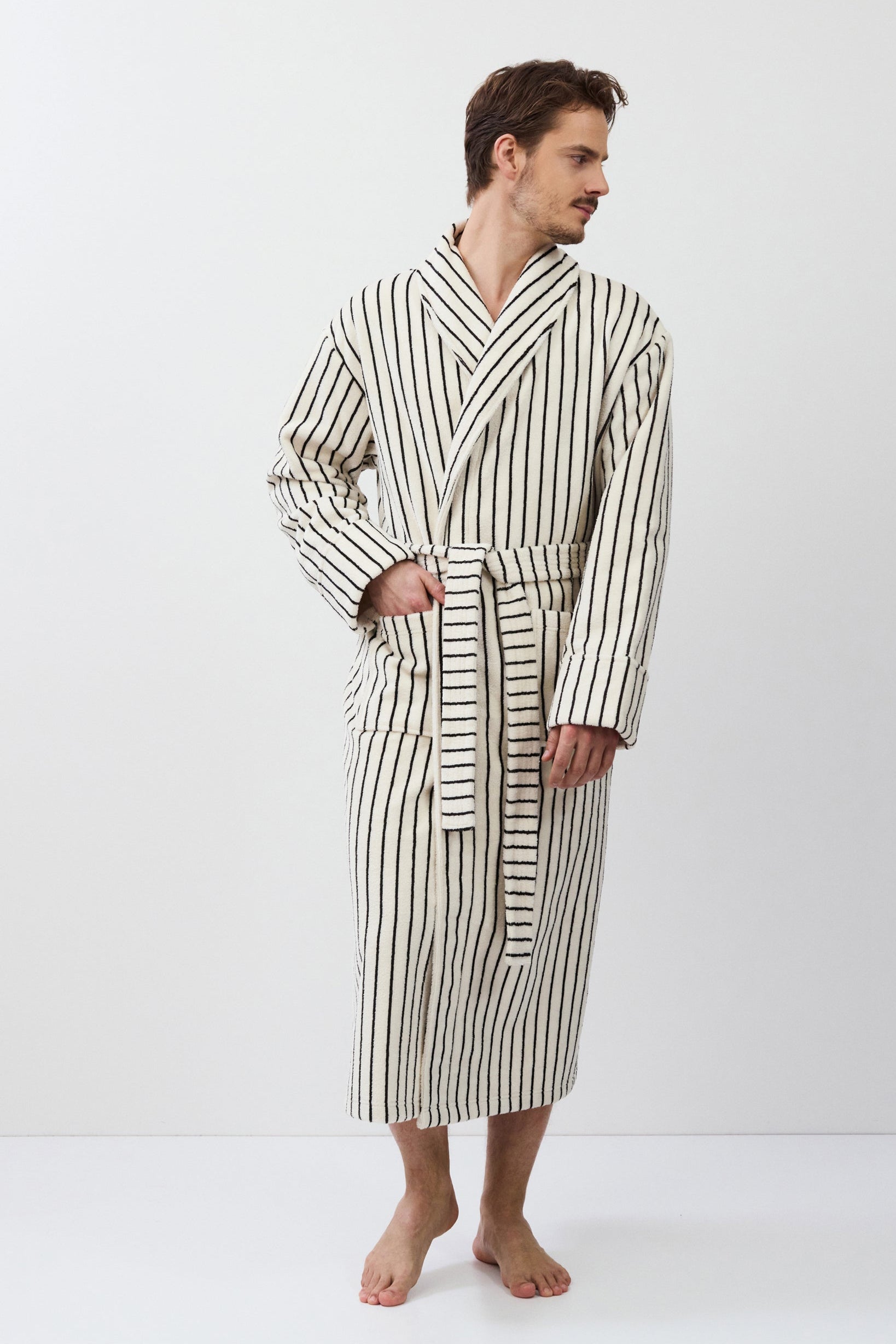 Man wearing a striped bathrobe on a white background