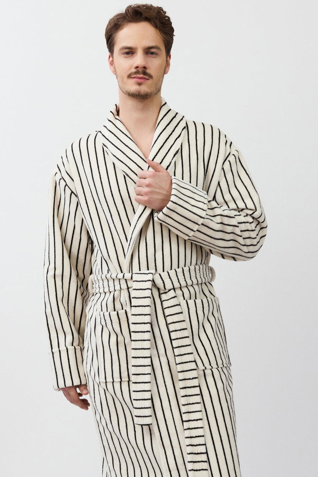 Man wearing a striped bathrobe on a white background