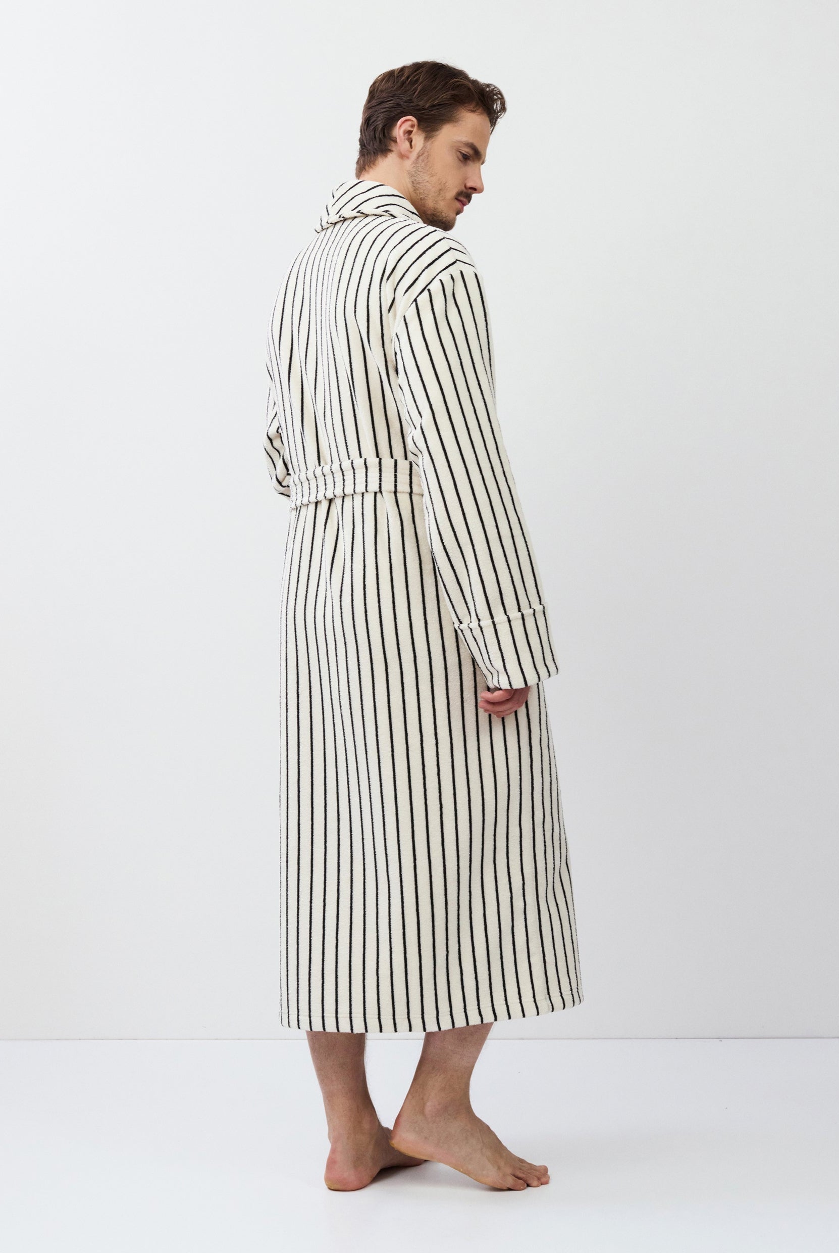 Man wearing a striped bathrobe against a white background