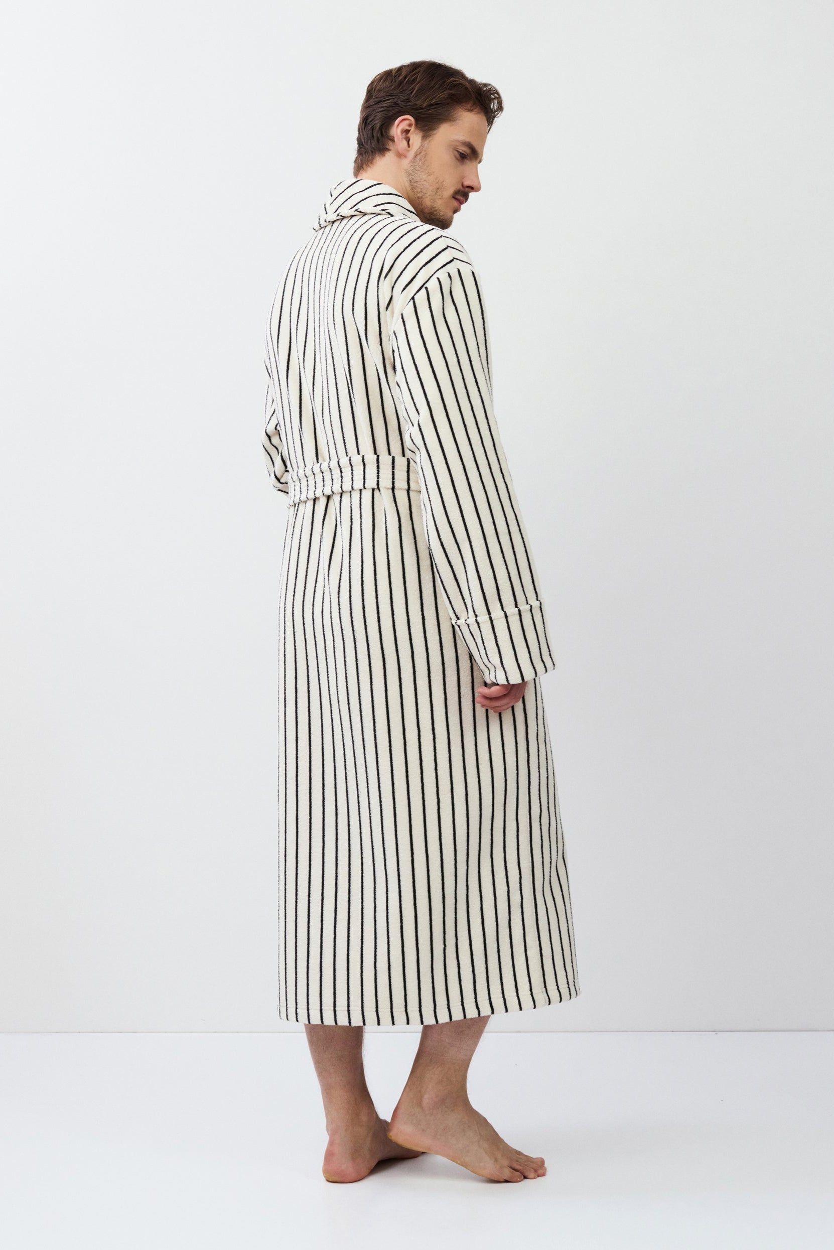 Man wearing a striped bathrobe against a white background
