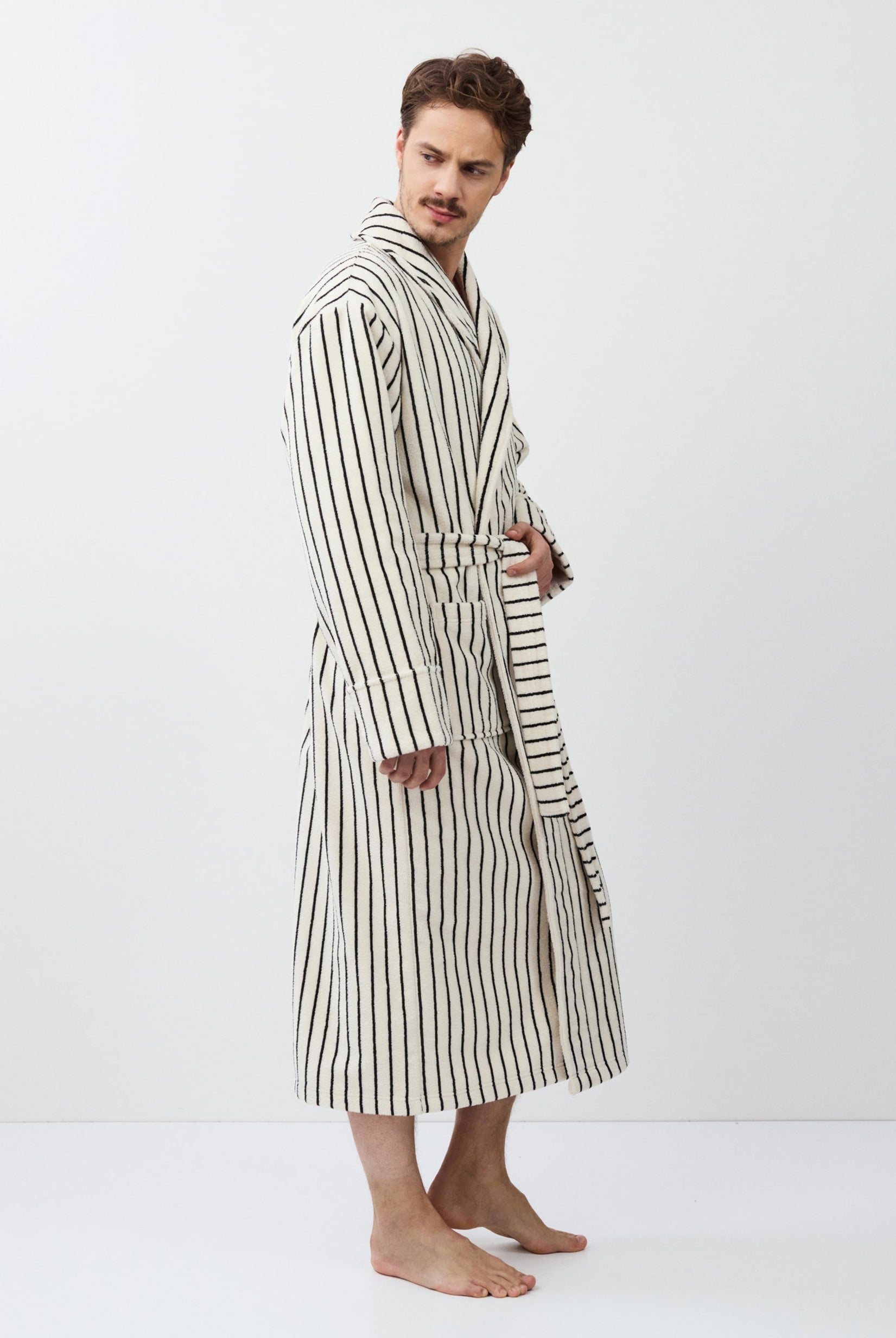 Man wearing a striped bathrobe against a white background