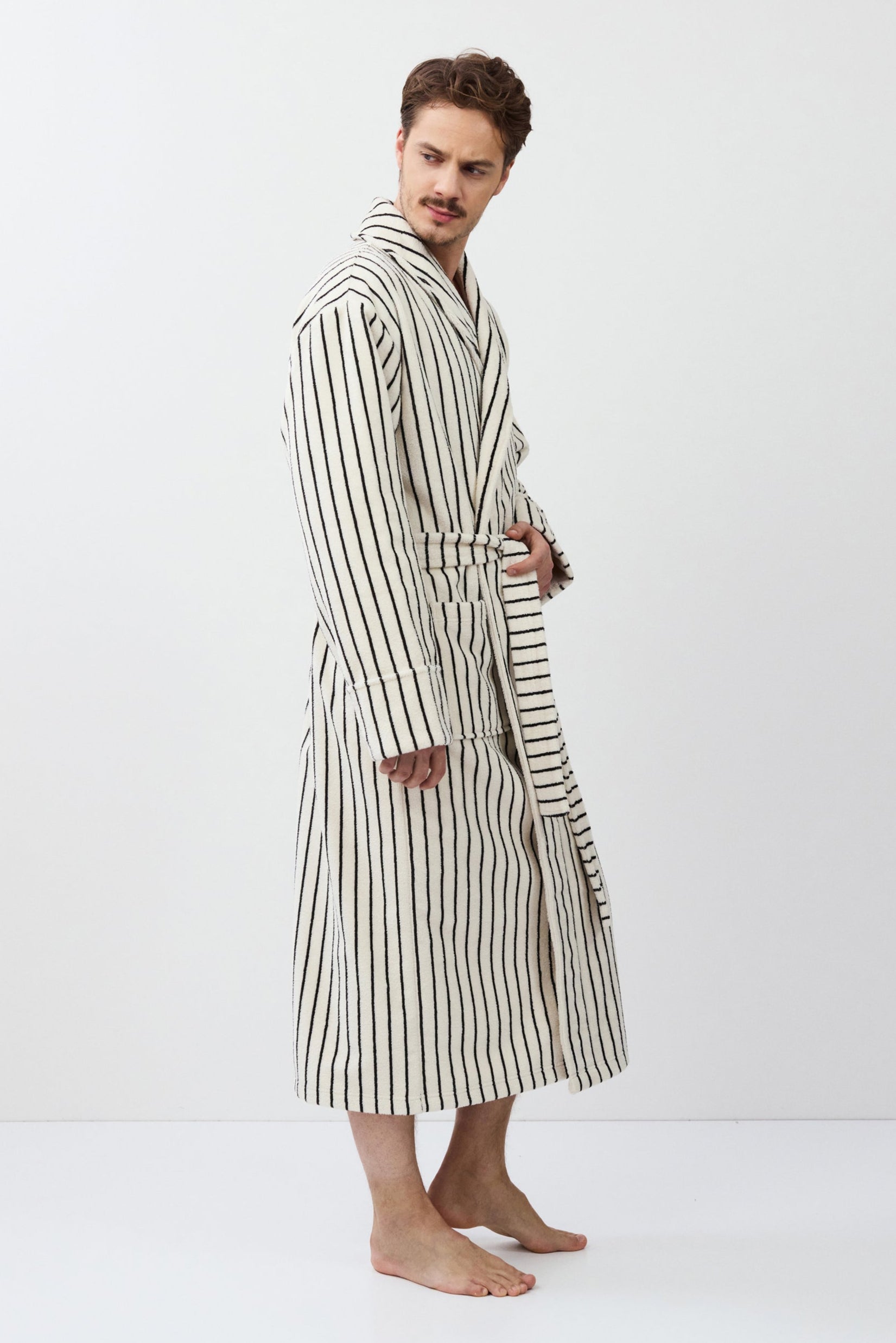 Man wearing a striped bathrobe against a white background