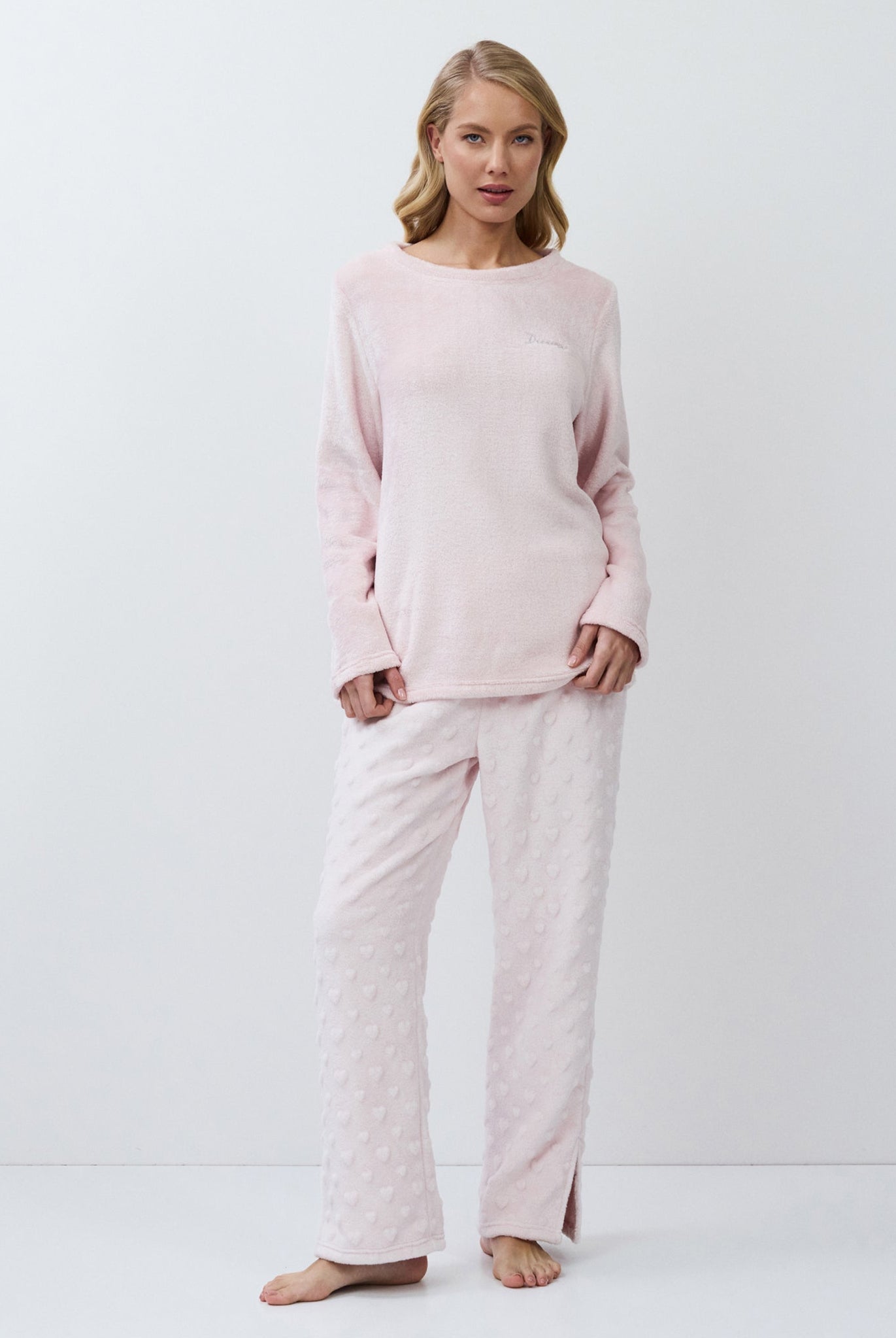 Woman wearing a pink set against a white background