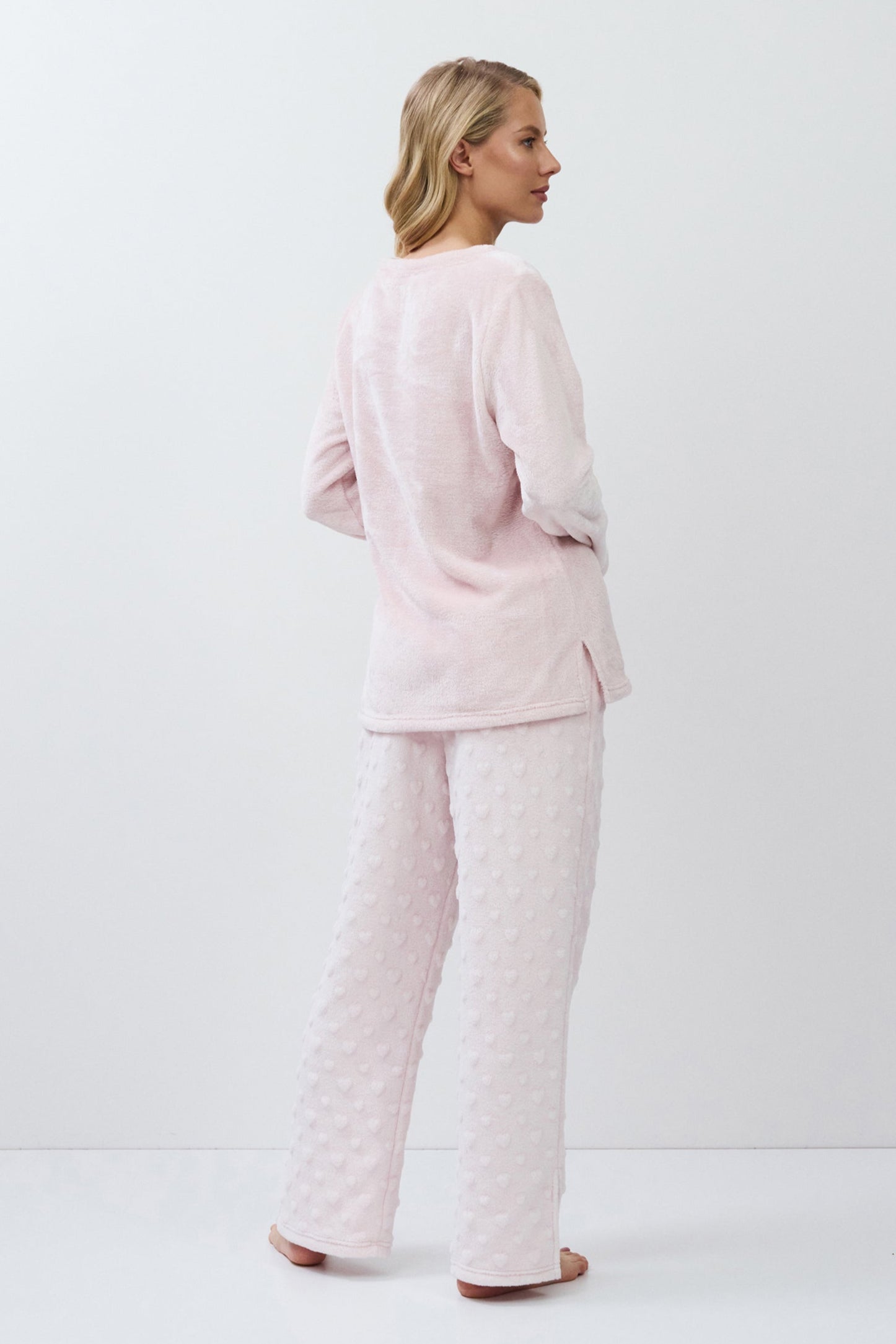 Woman wearing a pink quilted set on a white background