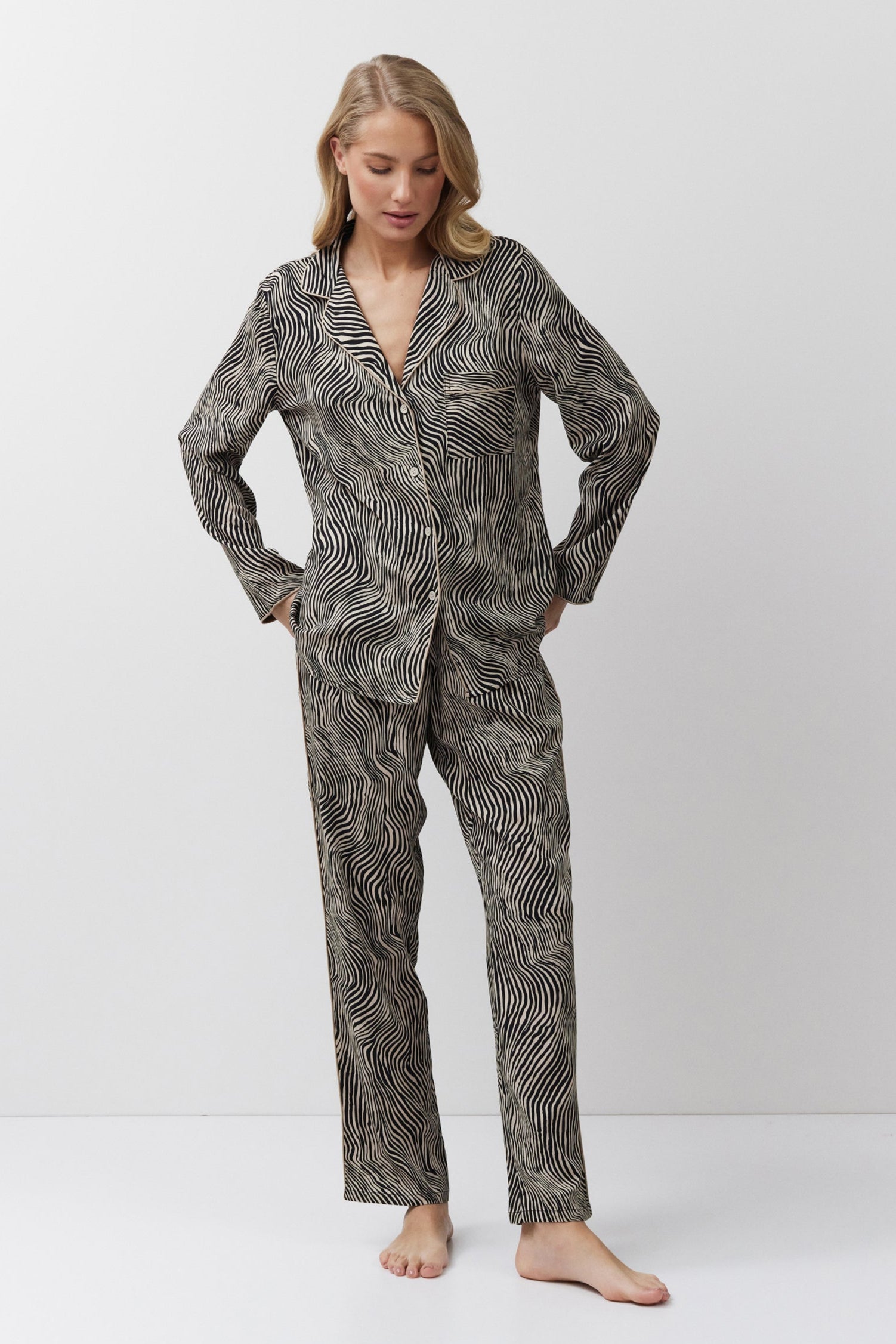 Woman wearing a patterned pajama set on a white background