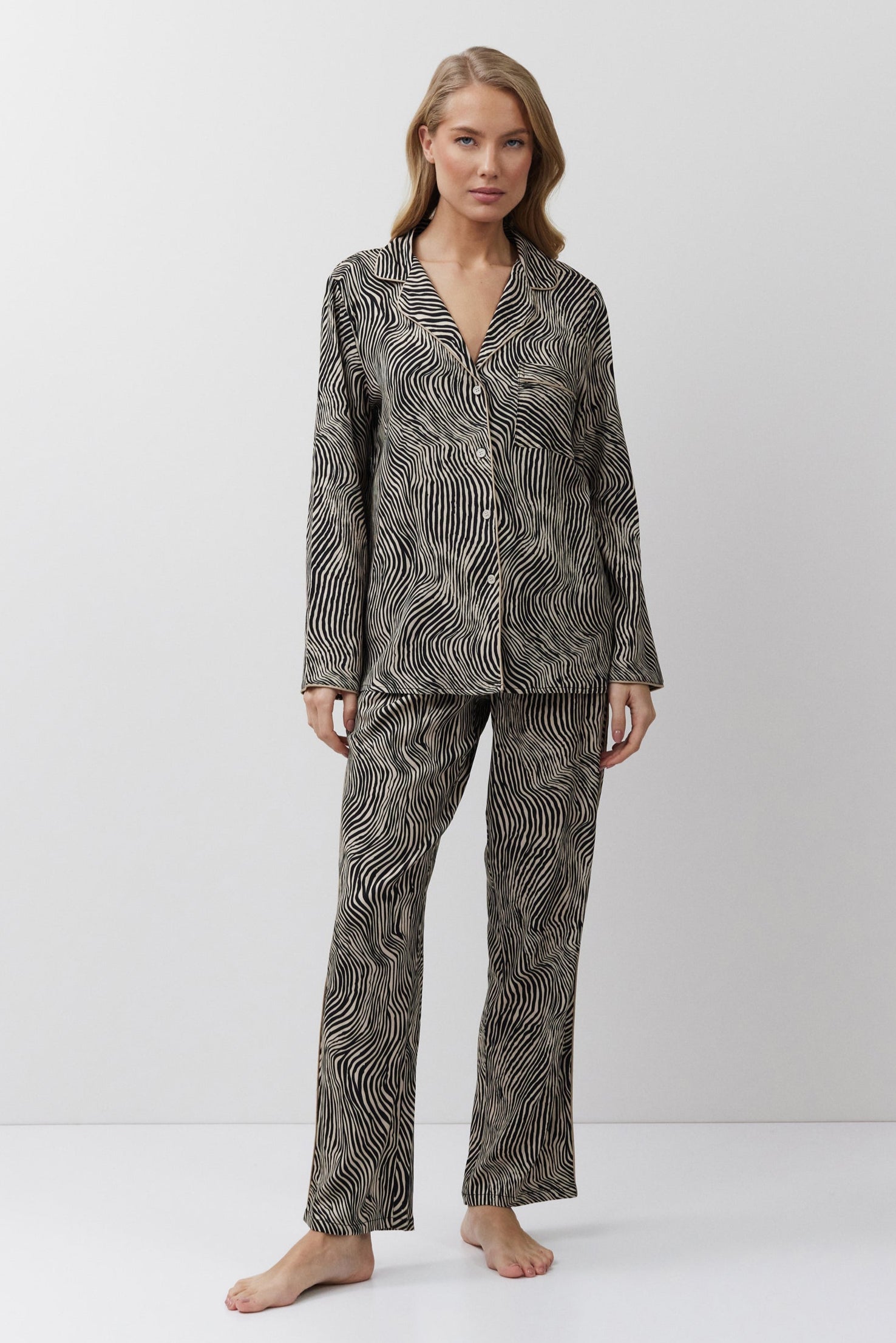 Woman wearing a patterned pajama set on a white background