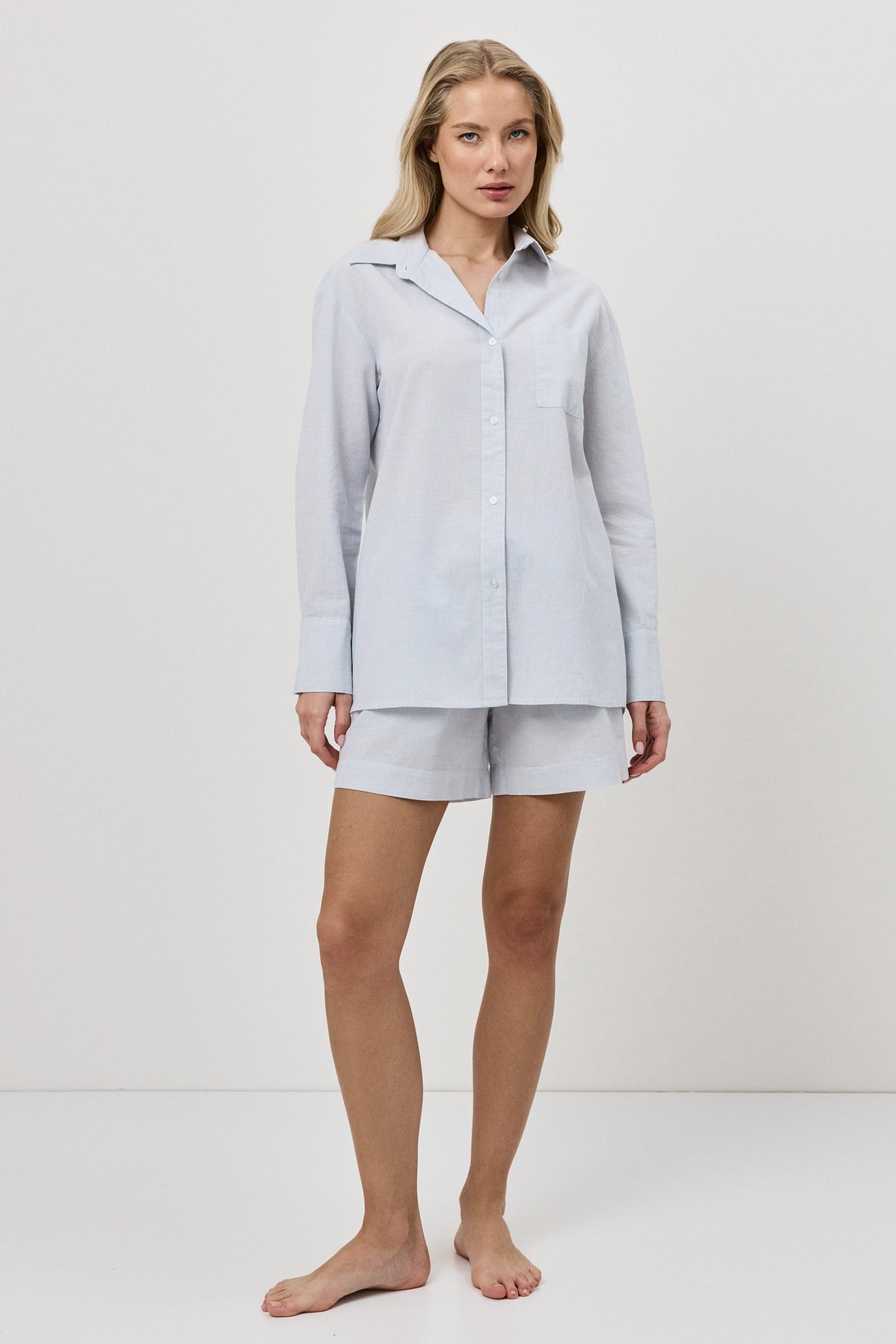 Woman wearing a blue resort wear set on a white background