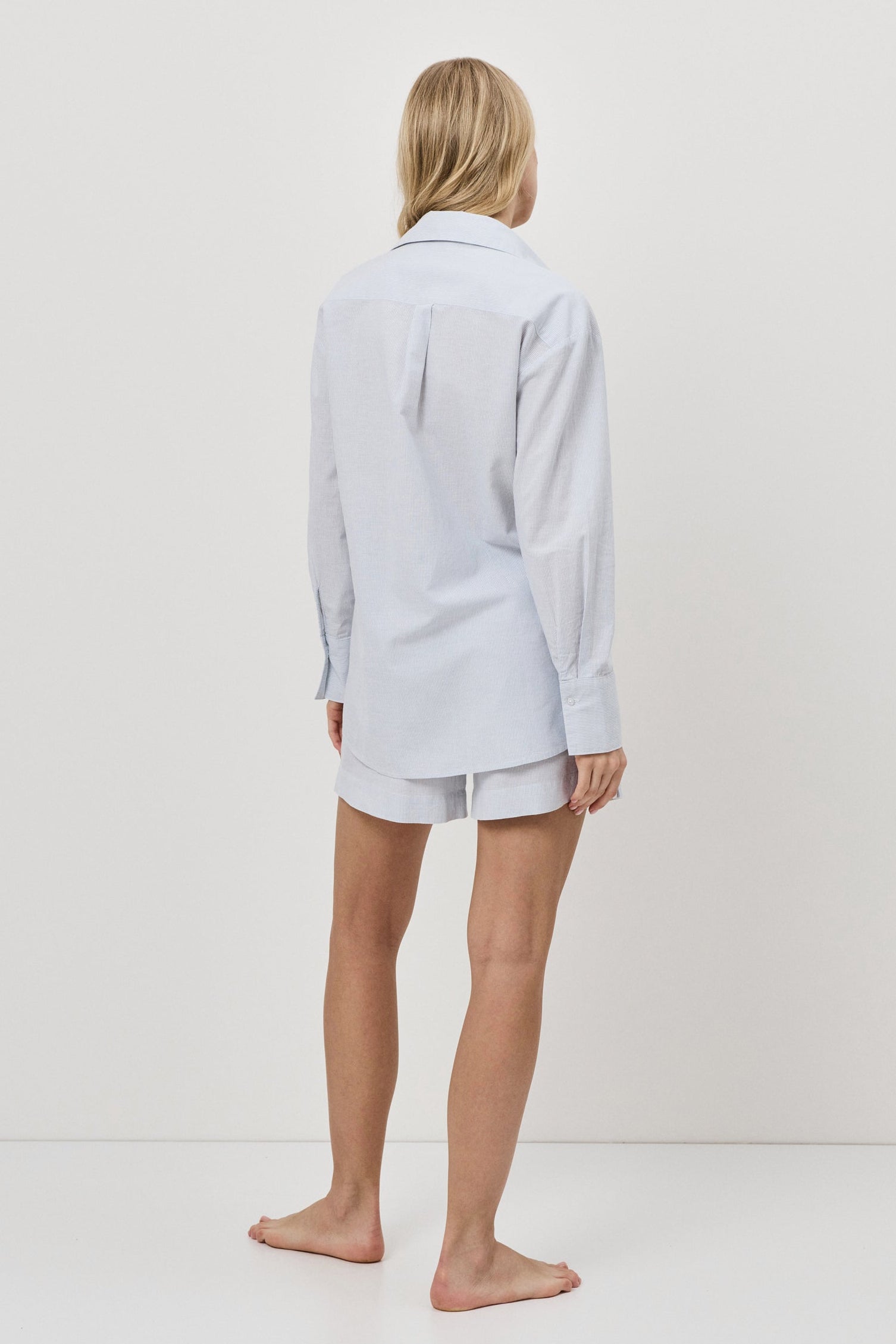 Person wearing a light blue resort wear set on a white background