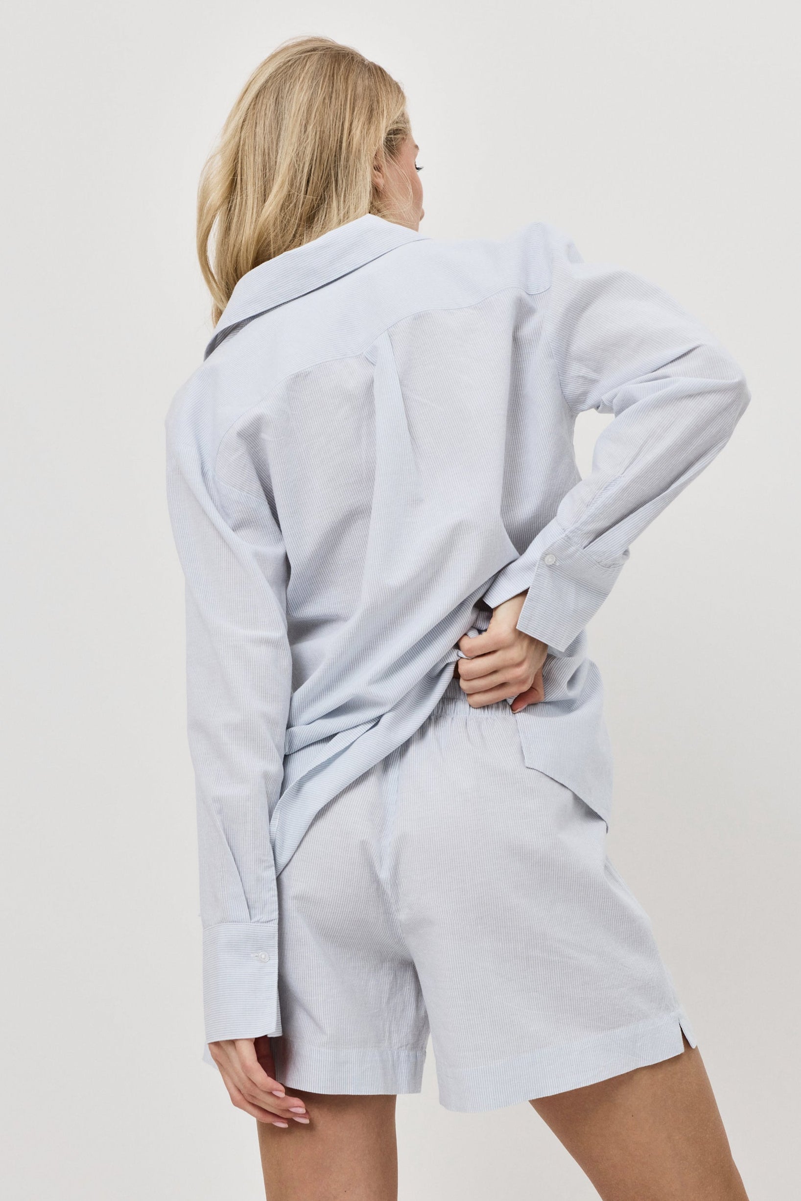 Person wearing a light blue resort wear set a plain background