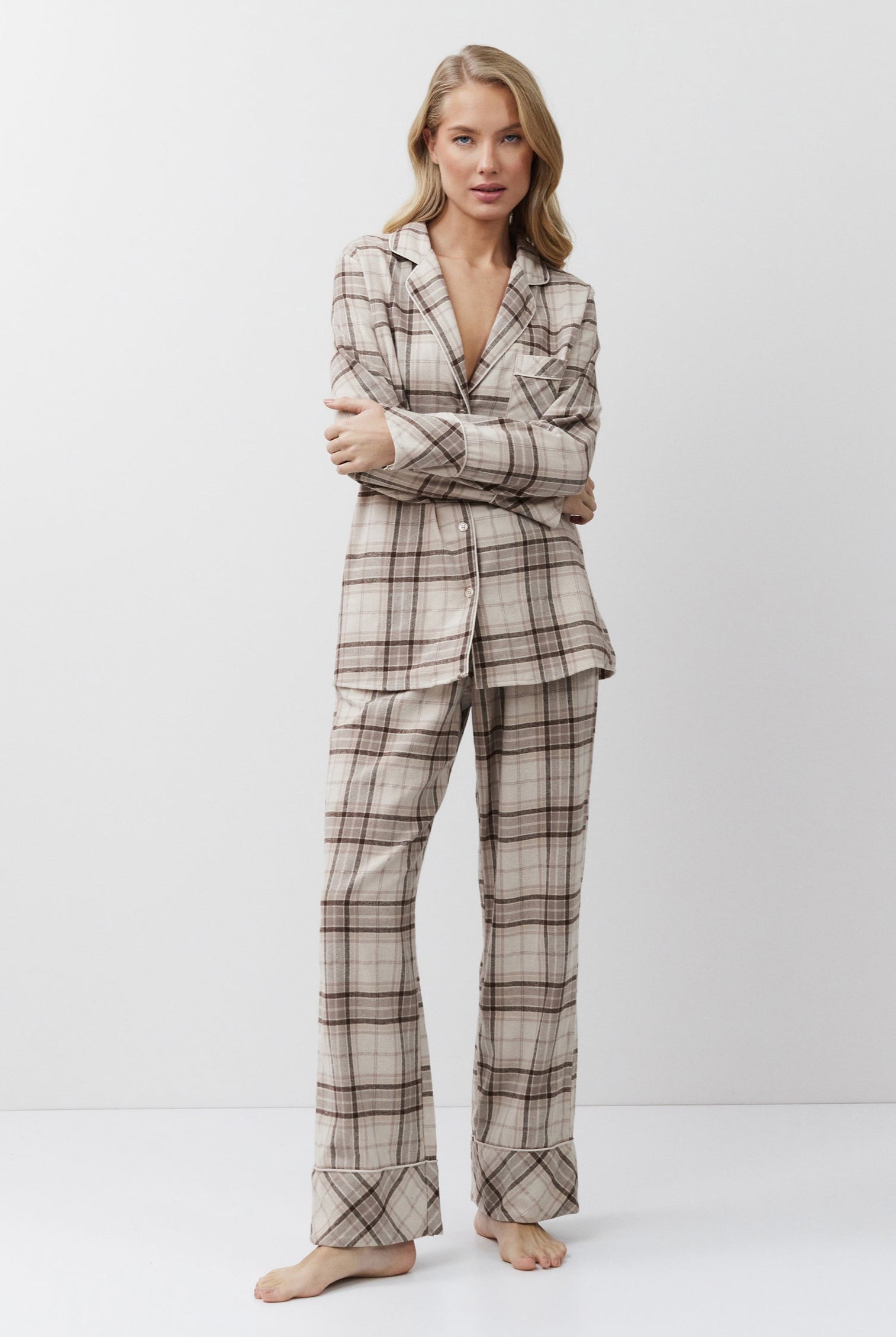Woman wearing a plaid pajama set on a white background