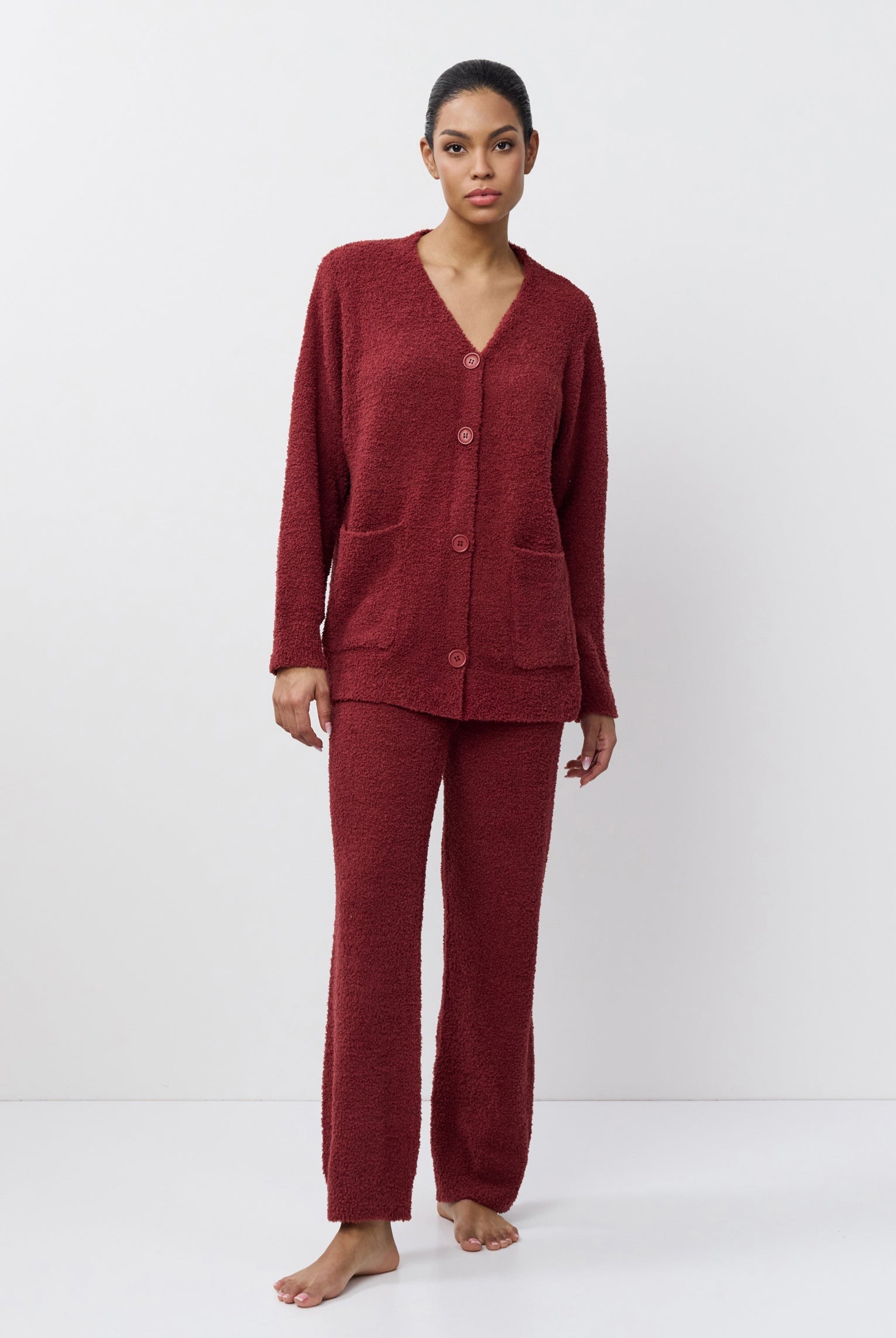 Woman wearing a burgundy pajama set on a white background