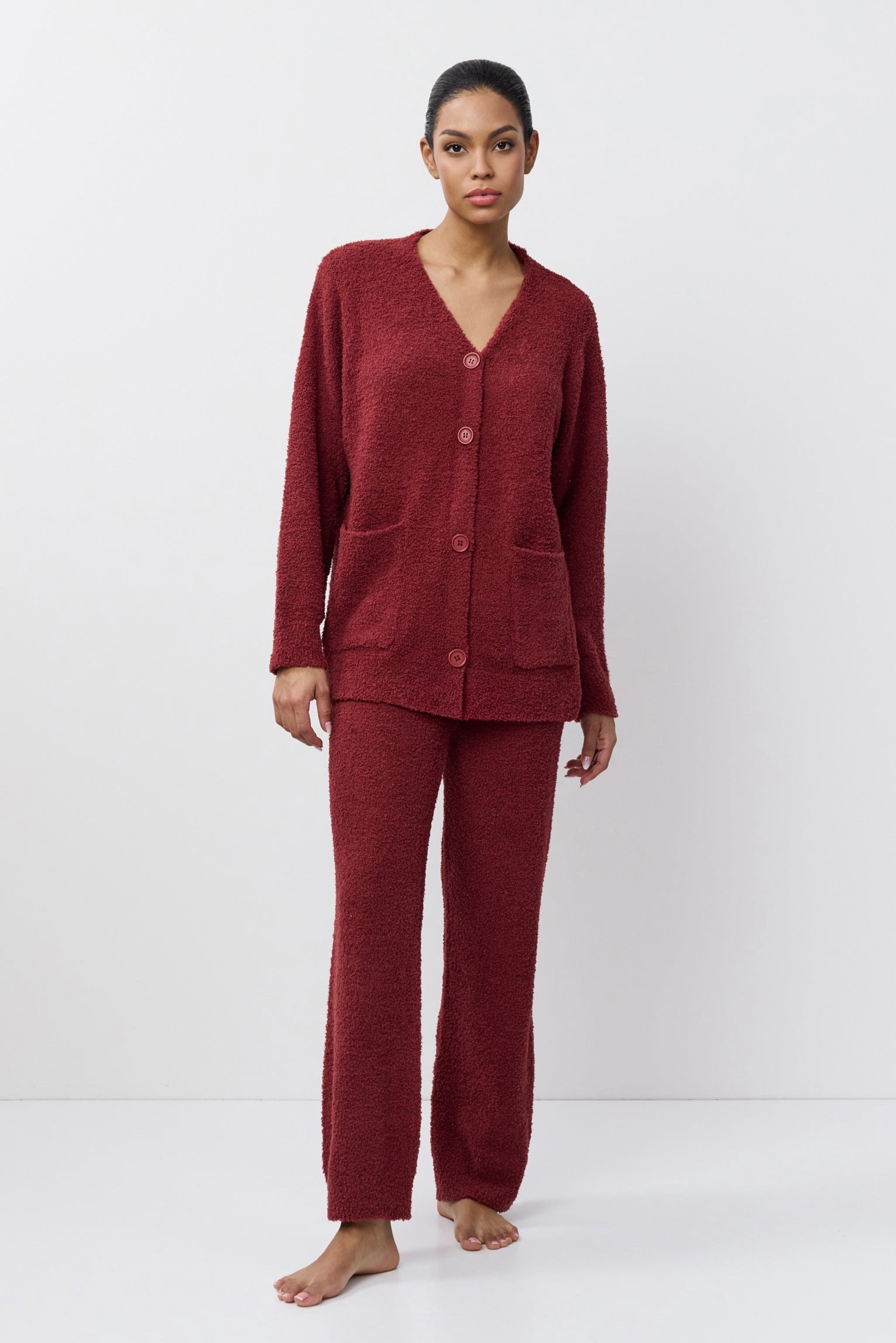 Woman wearing a burgundy pajama set on a white background