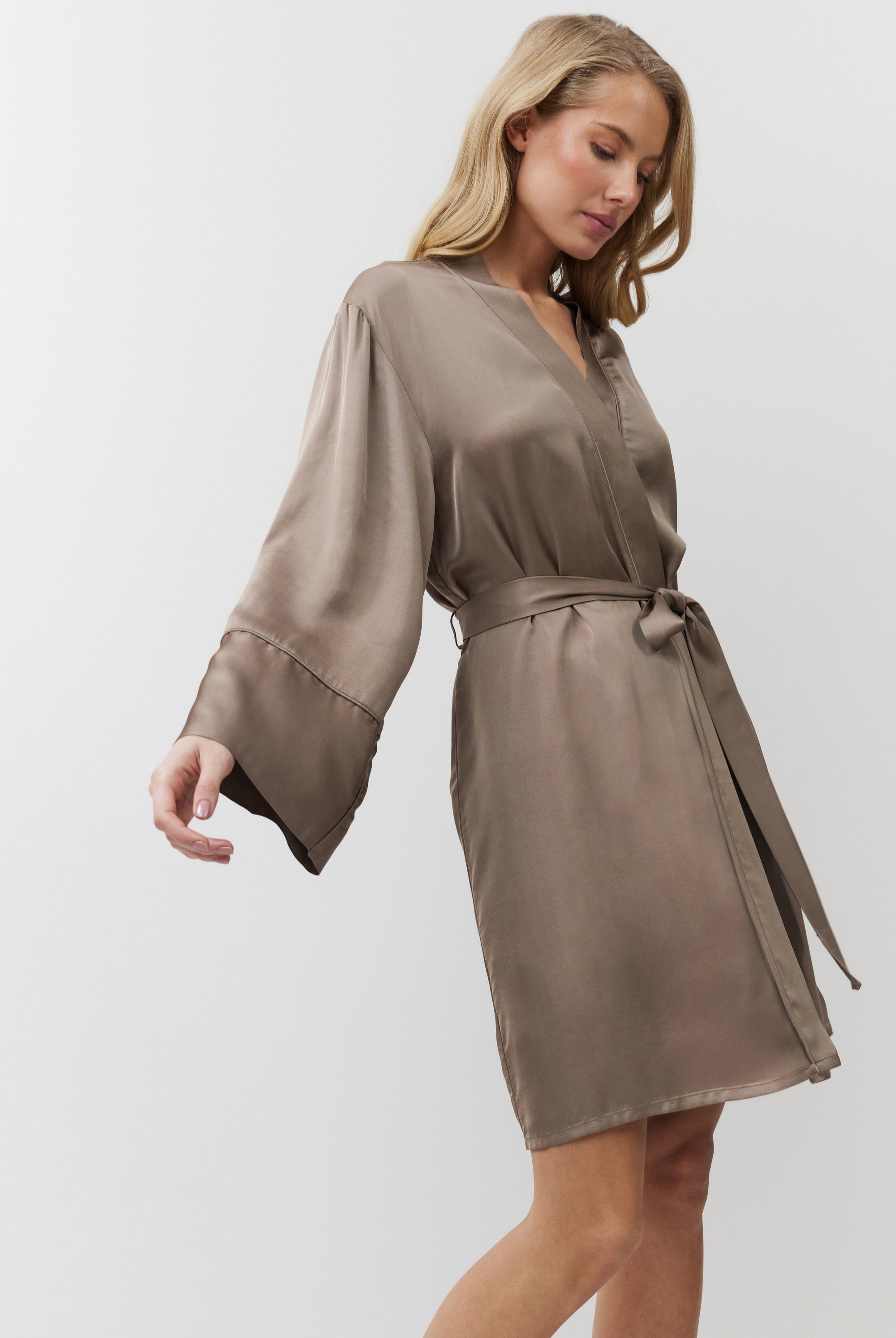 Woman wearing a choco gown with long sleeves on a white background