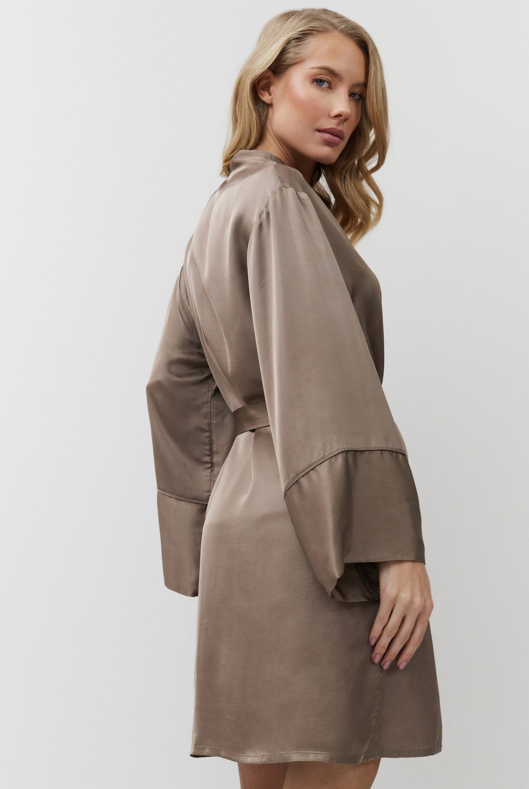 Woman wearing a brown gown with a white background