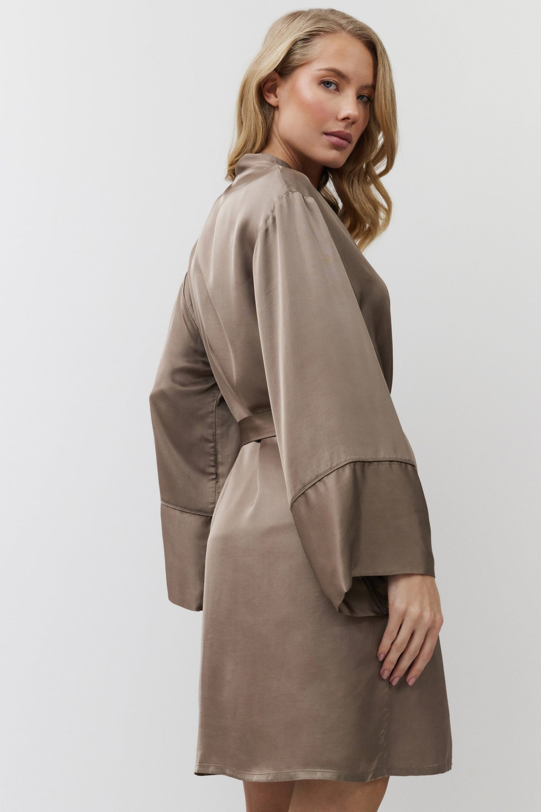 Woman wearing a brown gown with a white background