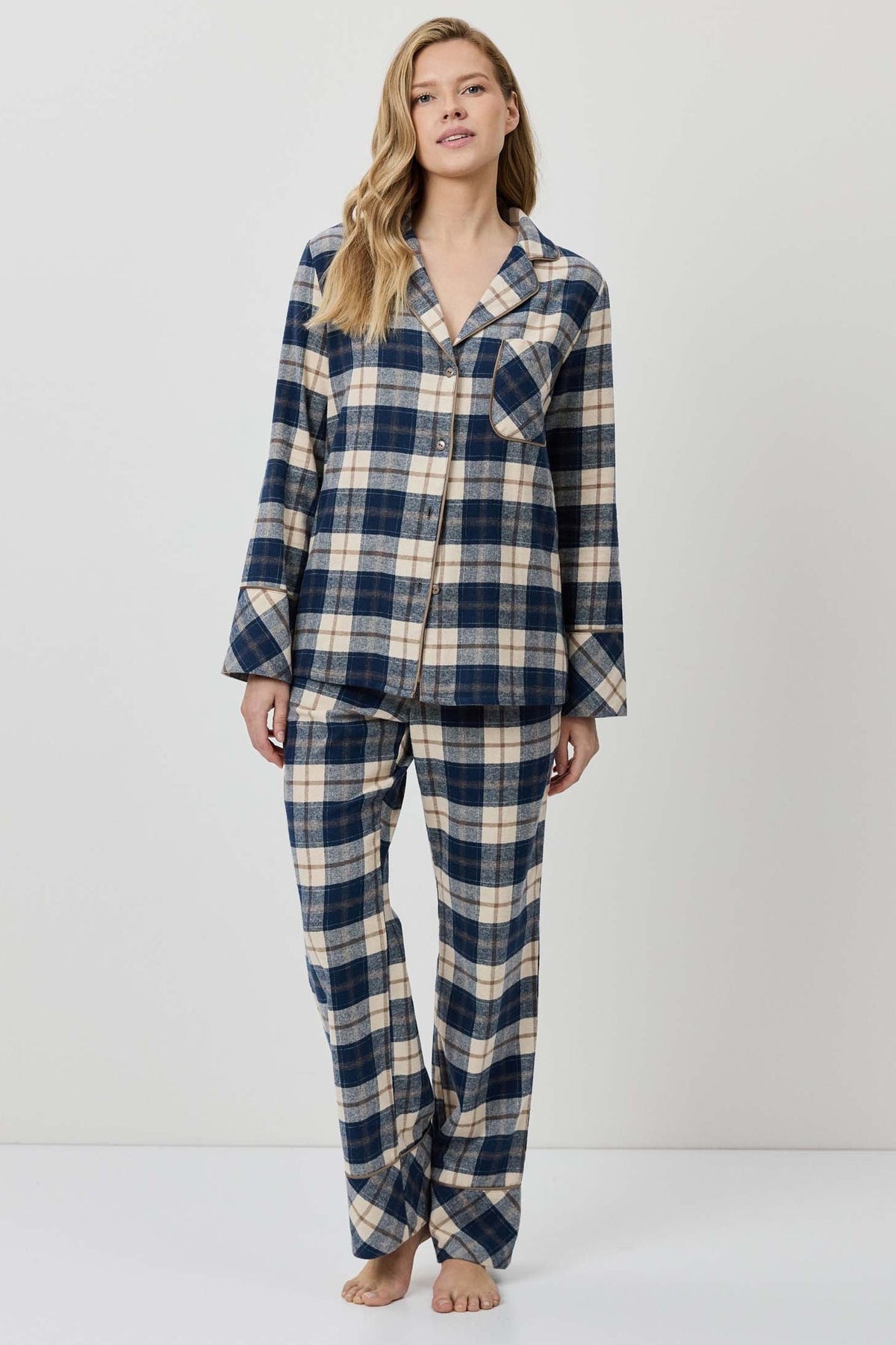 Woman wearing a blue and beige plaid pajama set on a white background
