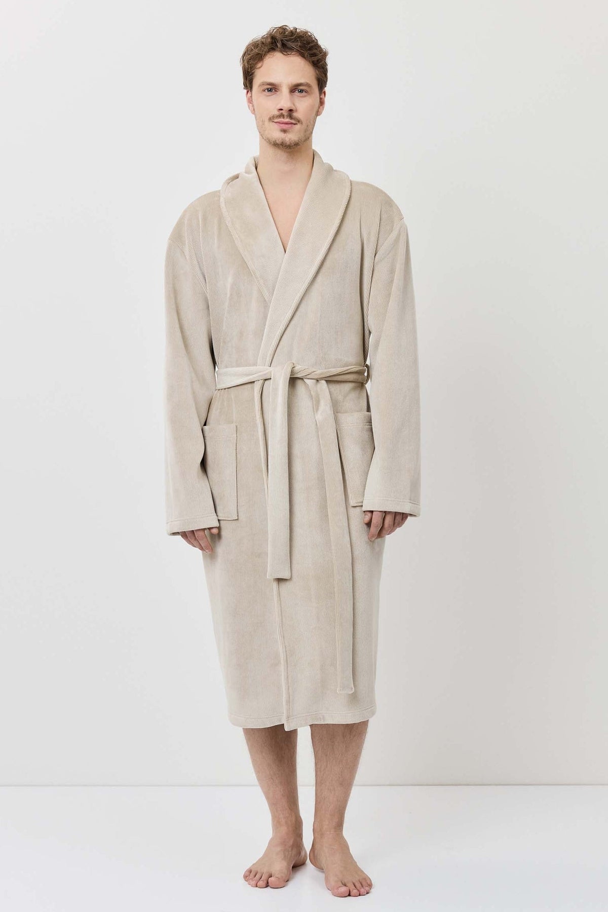 Man wearing a beige robe against a white background