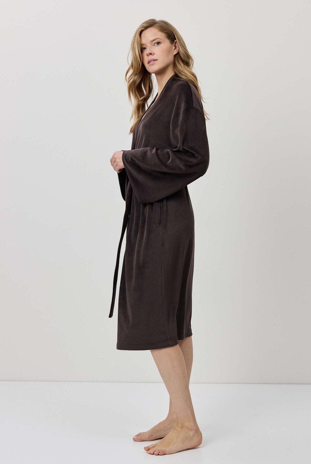 Woman wearing a brown robe against a white background