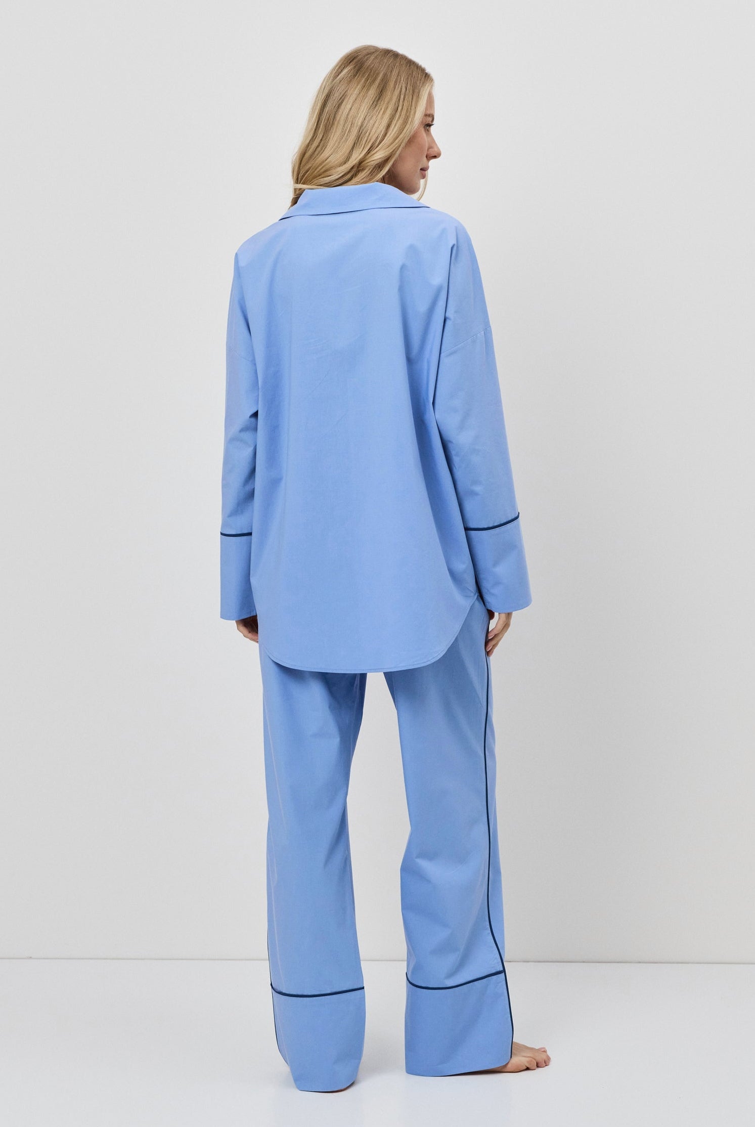 Person wearing a blue pajama set against a white background