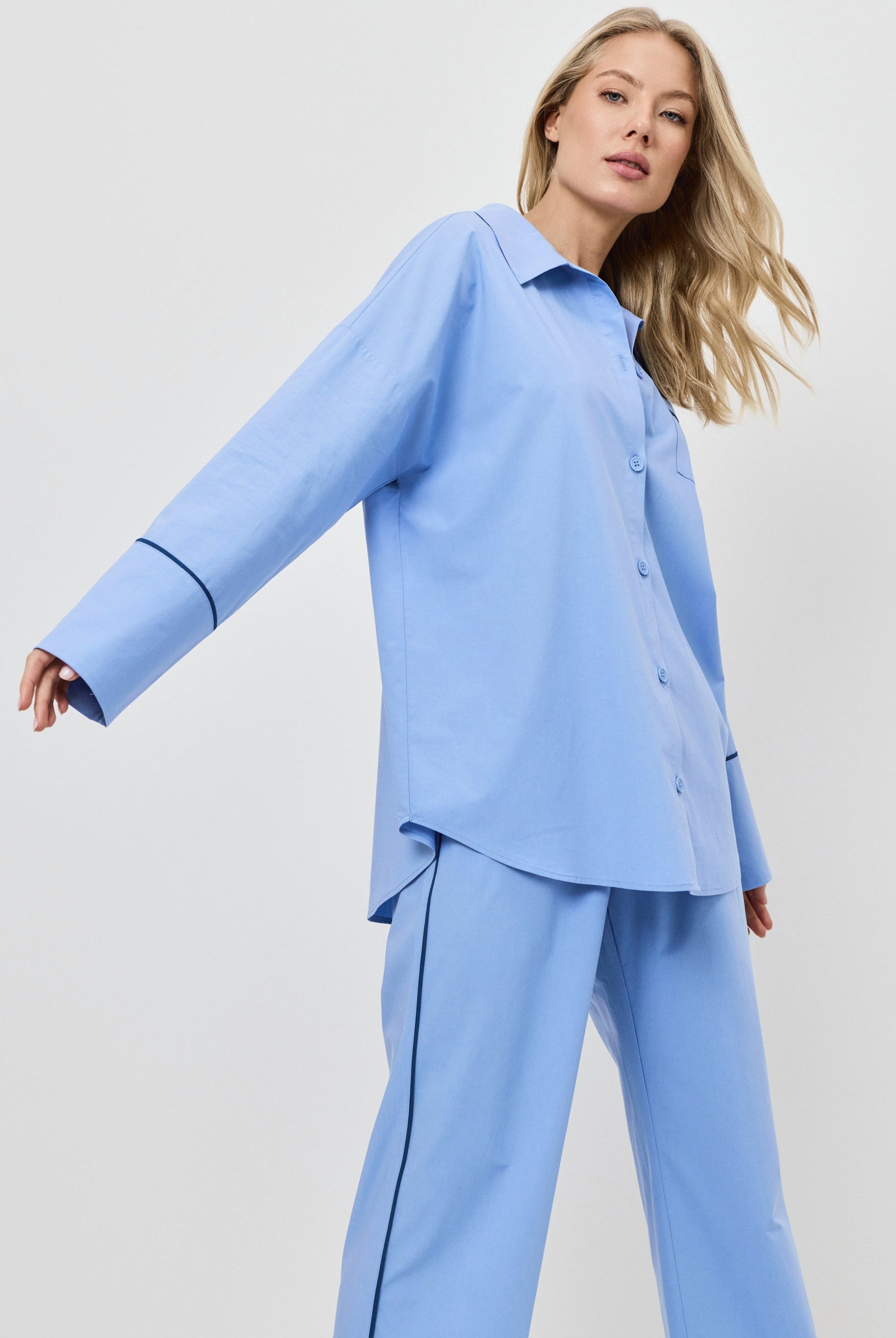 Woman wearing a blue pajama set on a white background