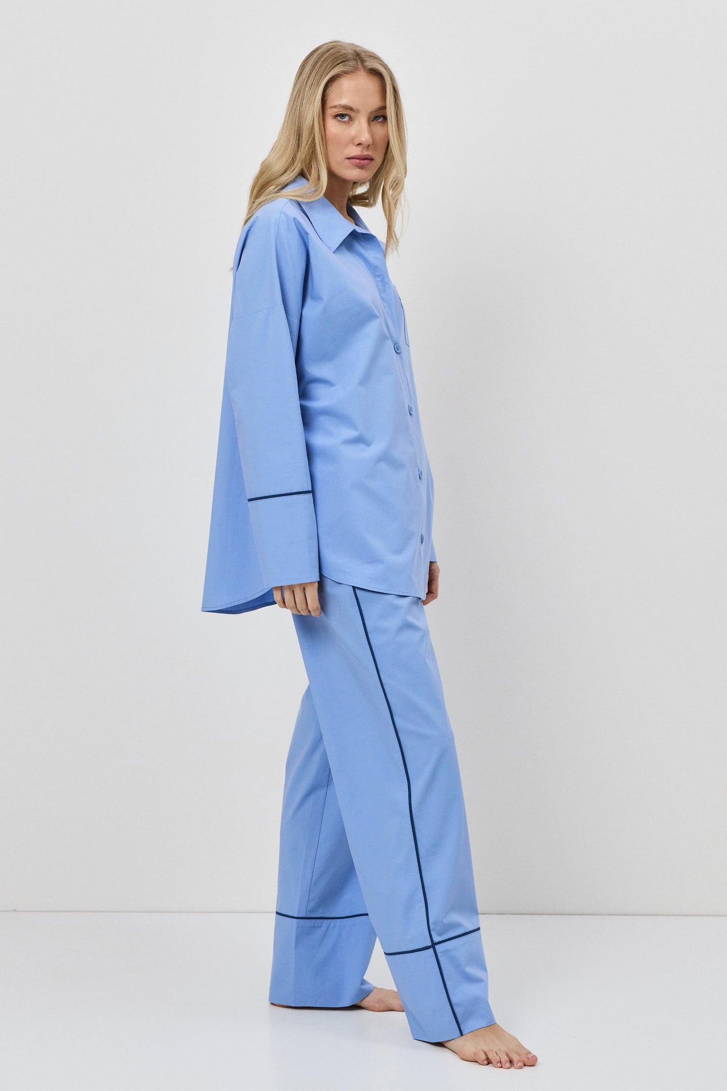 Woman wearing a blue pajama set against a white background