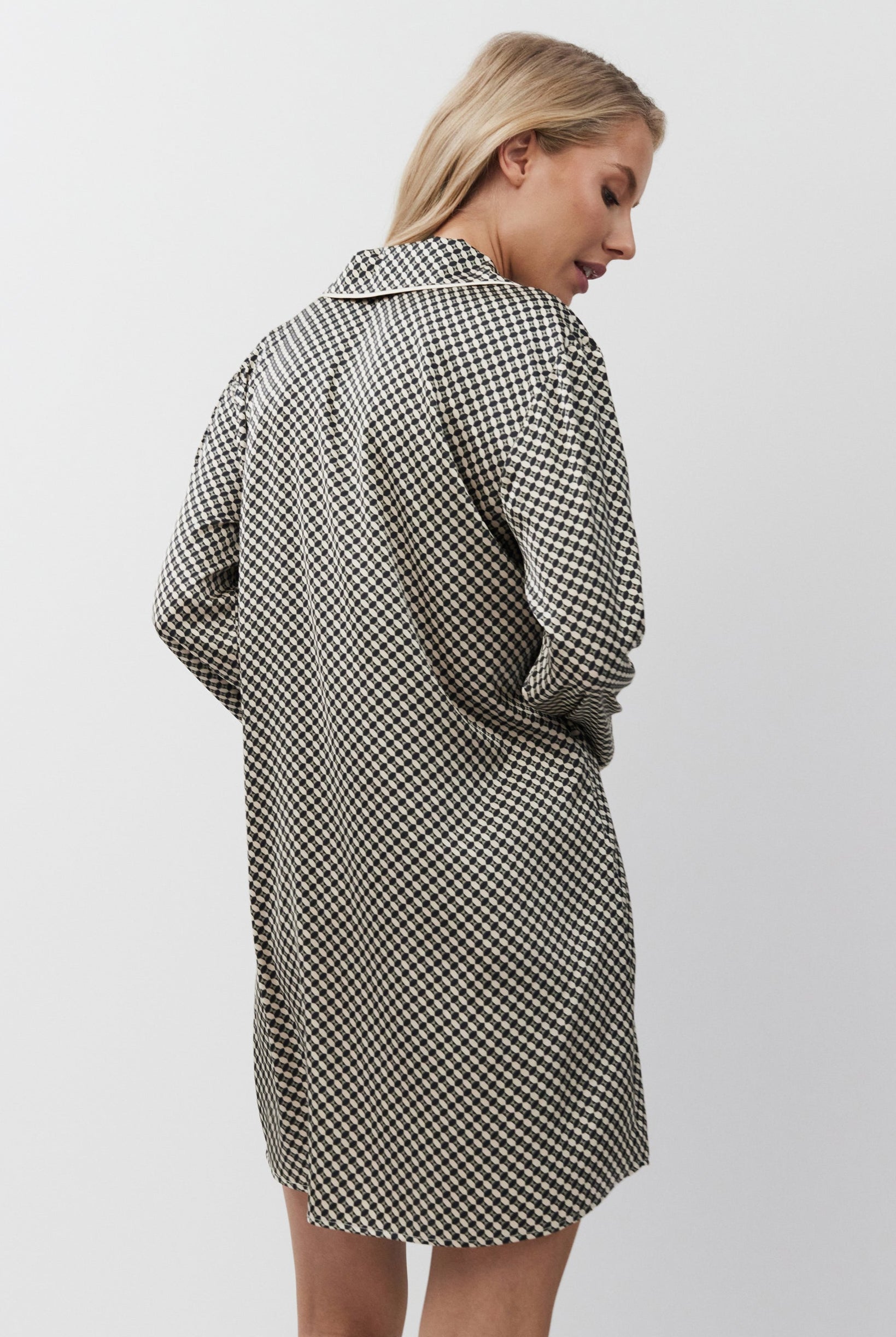 Woman wearing a checkered nightdress on a white background