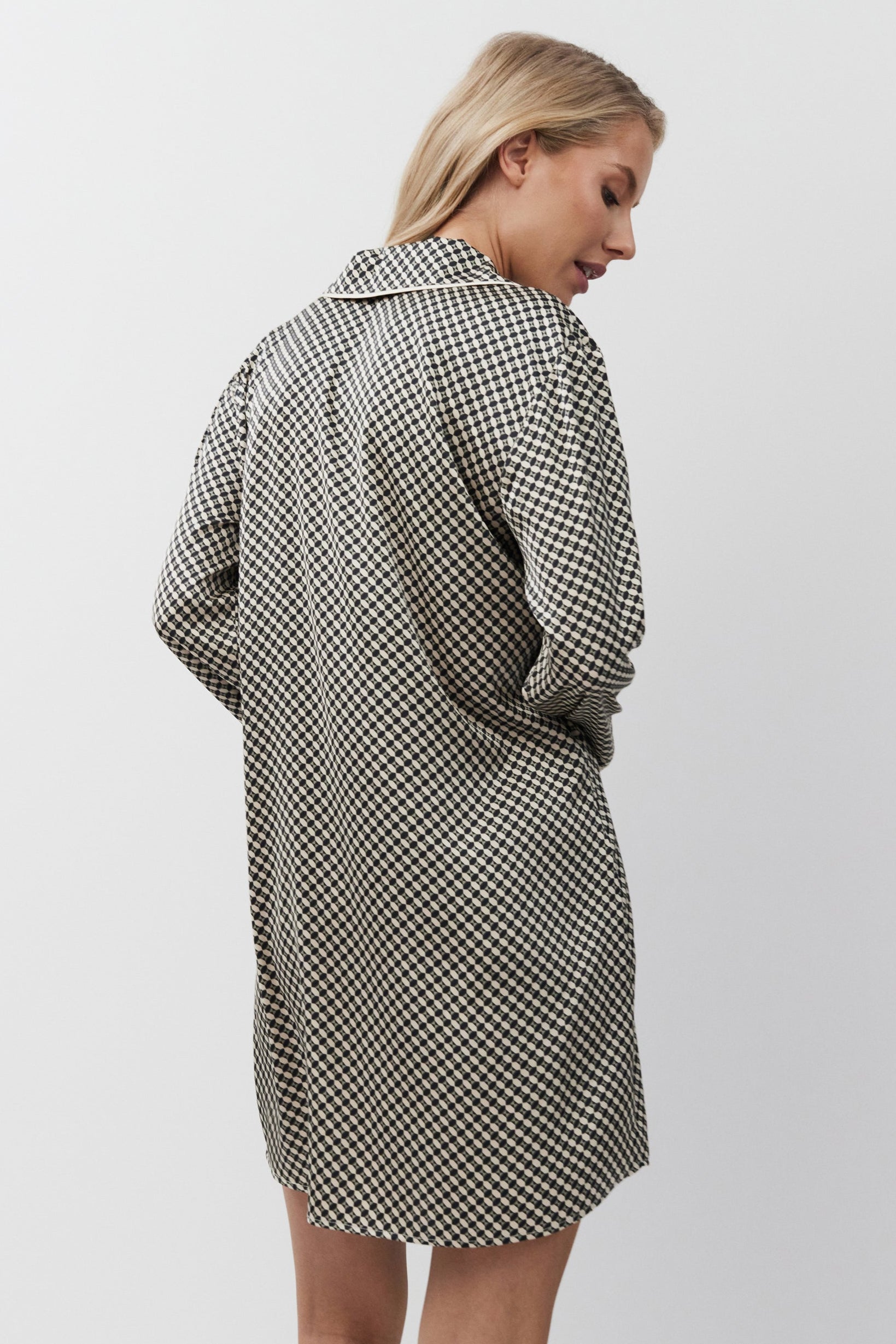 Woman wearing a checkered nightdress on a white background