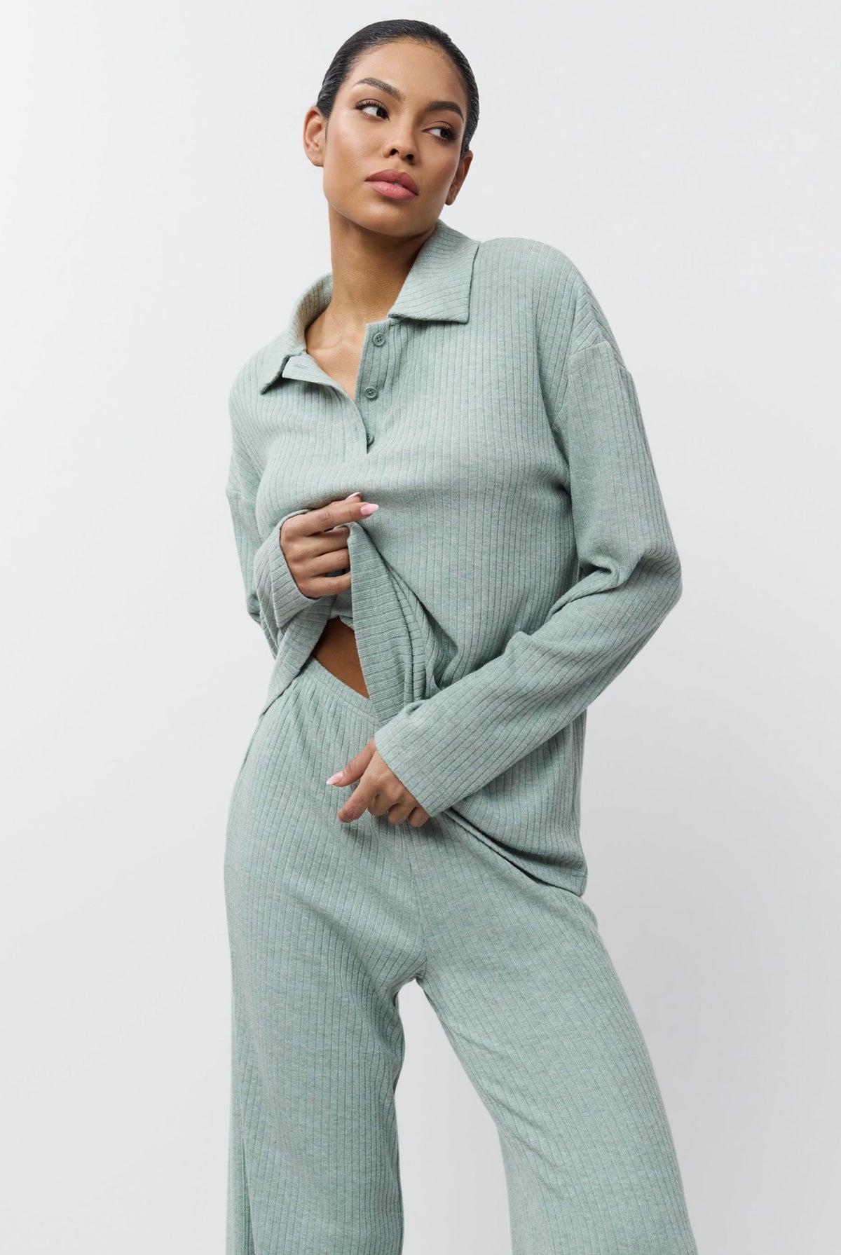 Woman wearing a light green ribbed knit outfit on a white background