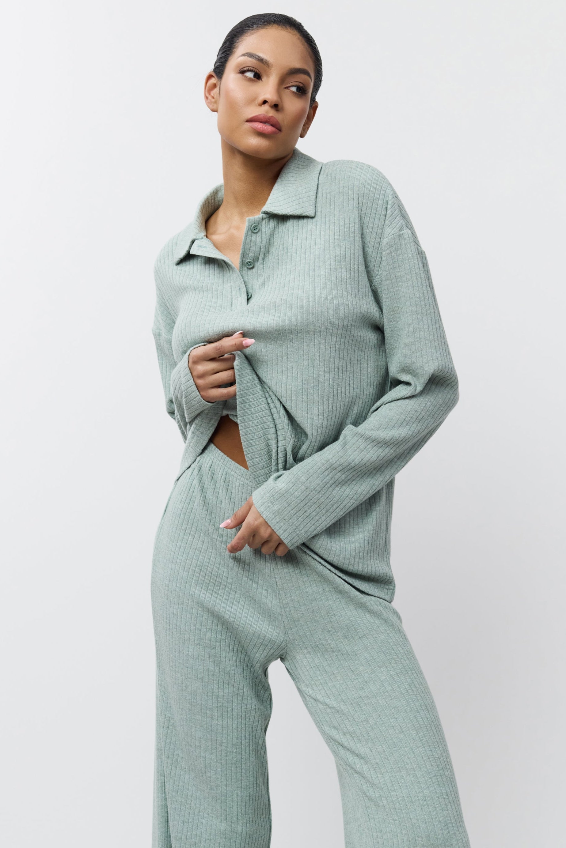 Woman wearing a light green ribbed knit outfit on a white background