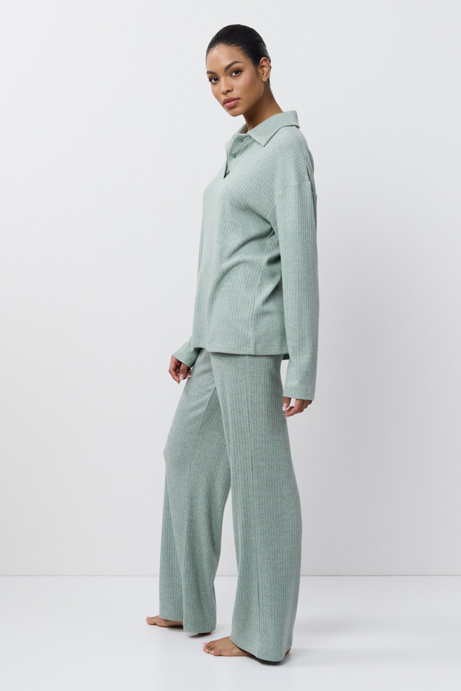 Person wearing a light green outfit on a white background