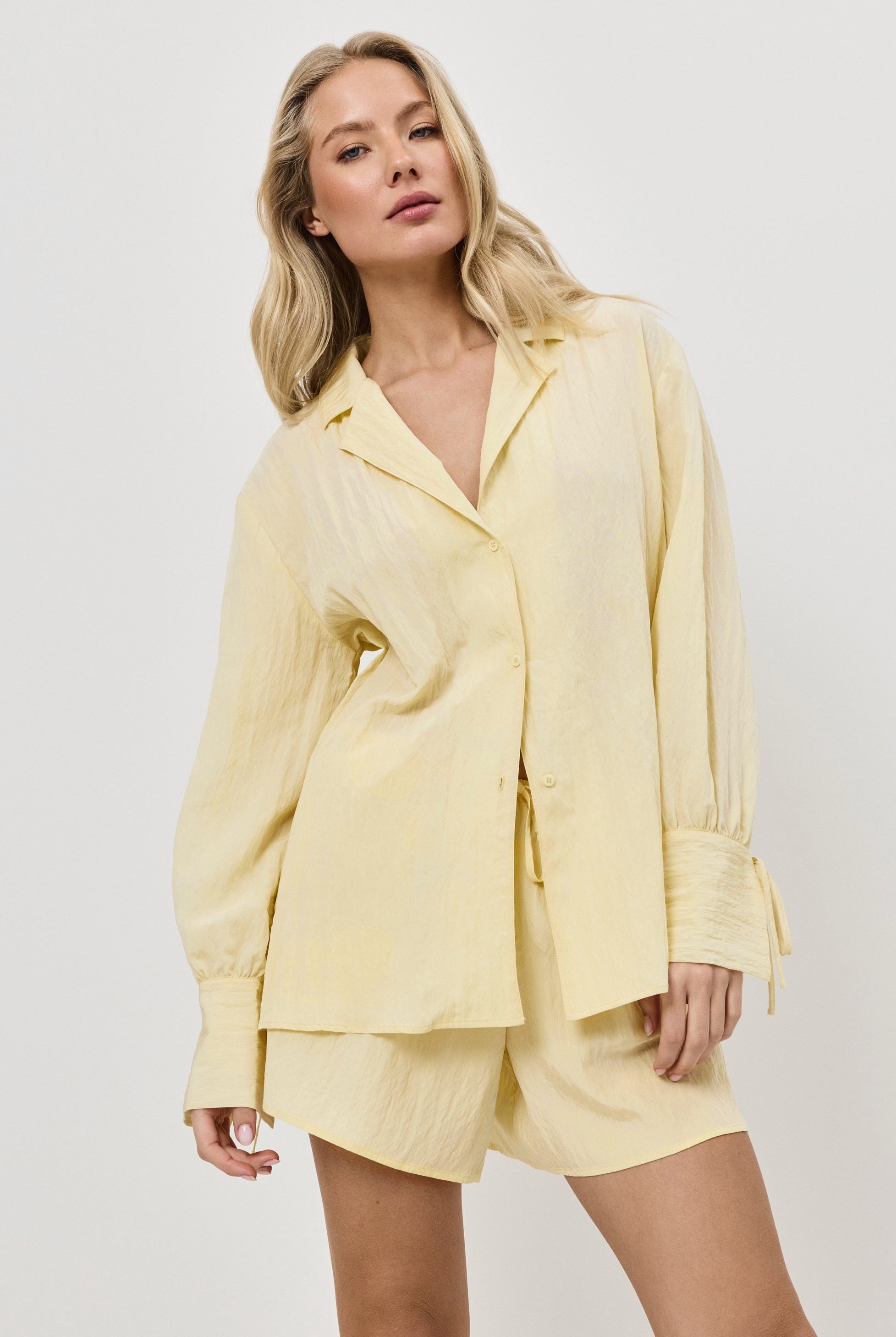 Woman wearing a light yellow resort wear set on a white background