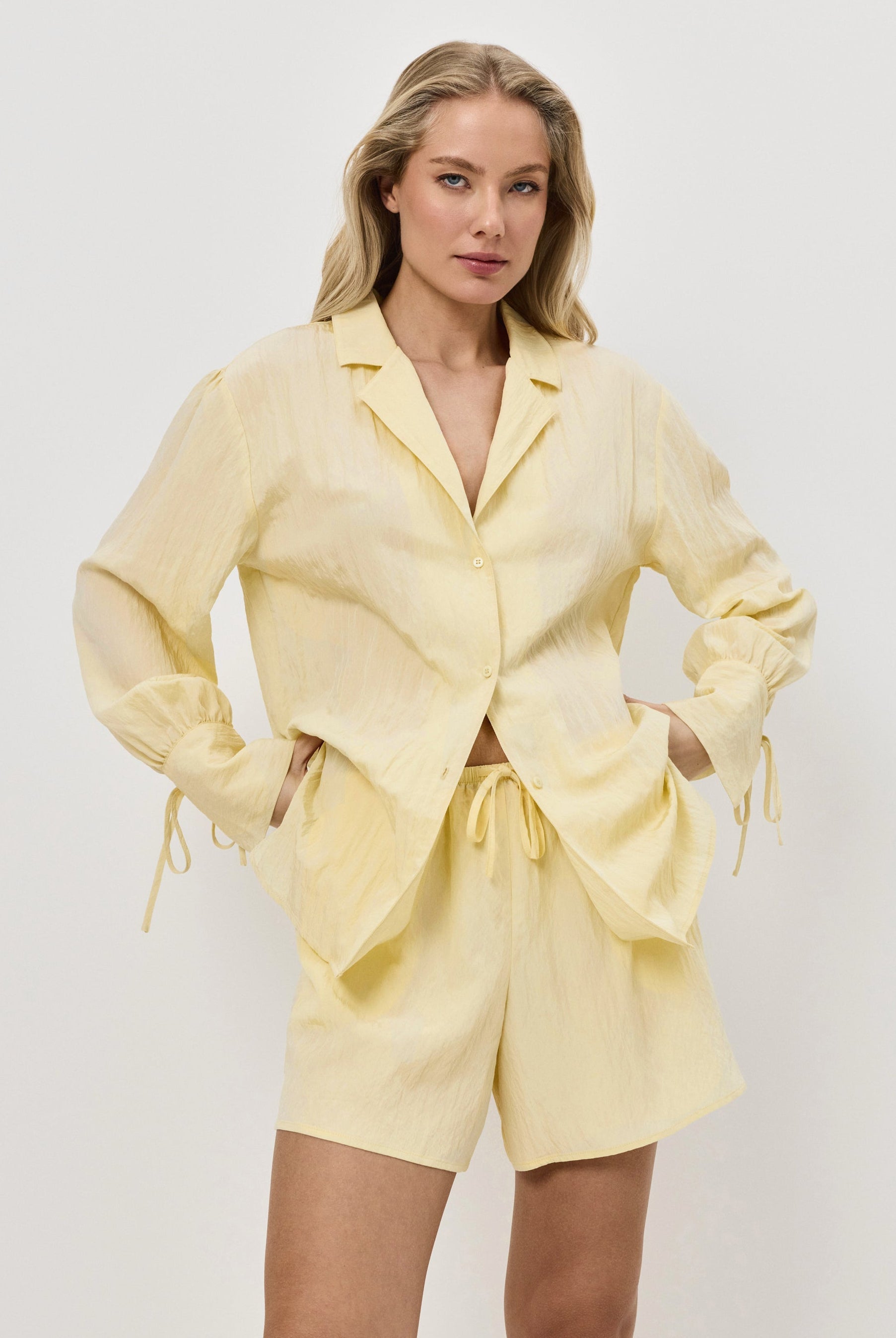 Woman wearing a yellow resort wear set on a white background