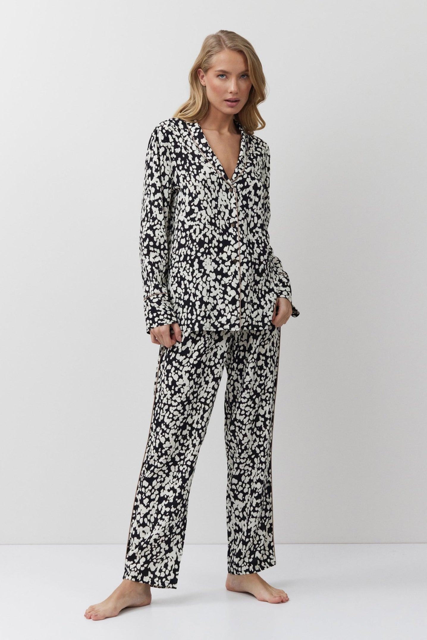 Woman wearing a black and white patterned pajama set on a white background