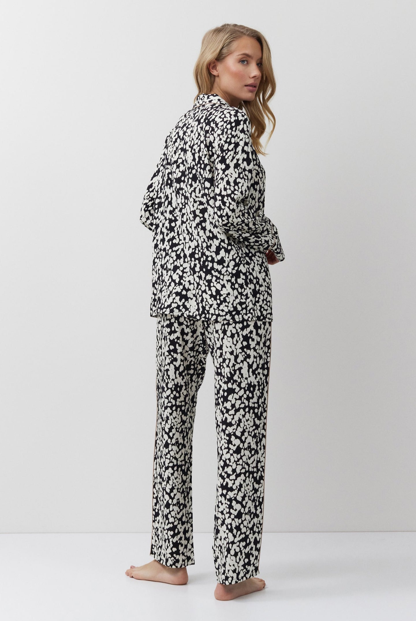 Woman wearing a black and white patterned onesie on a white background