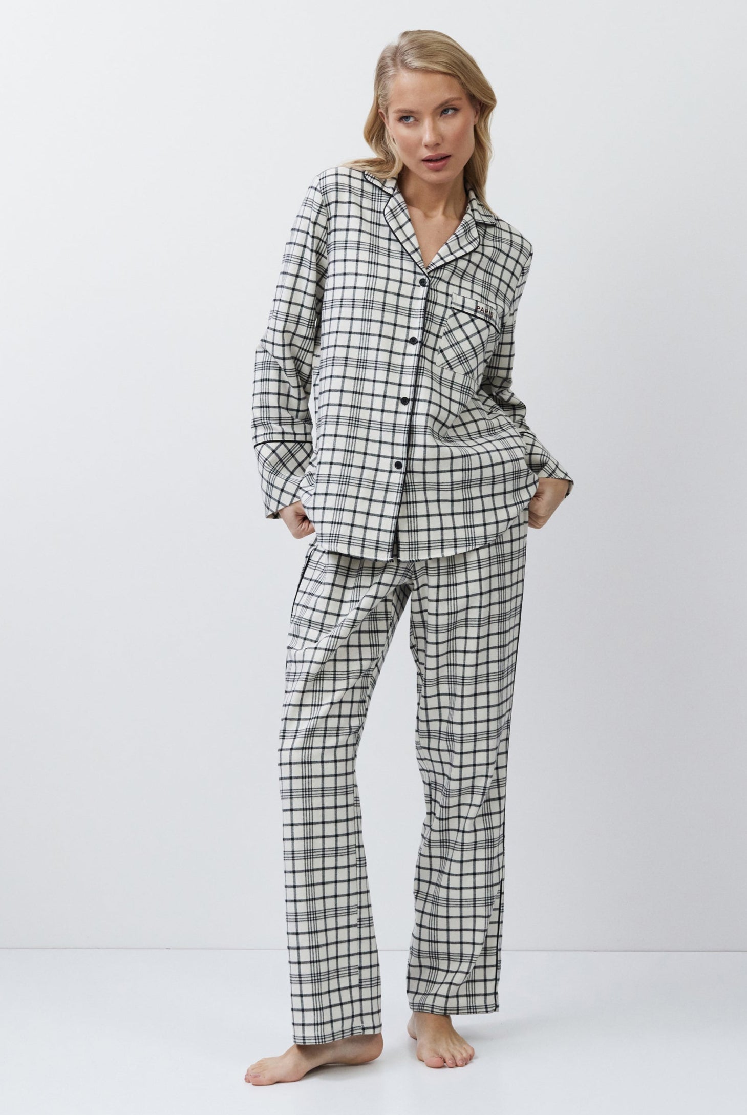 Woman wearing a checkered pajama set on a white background