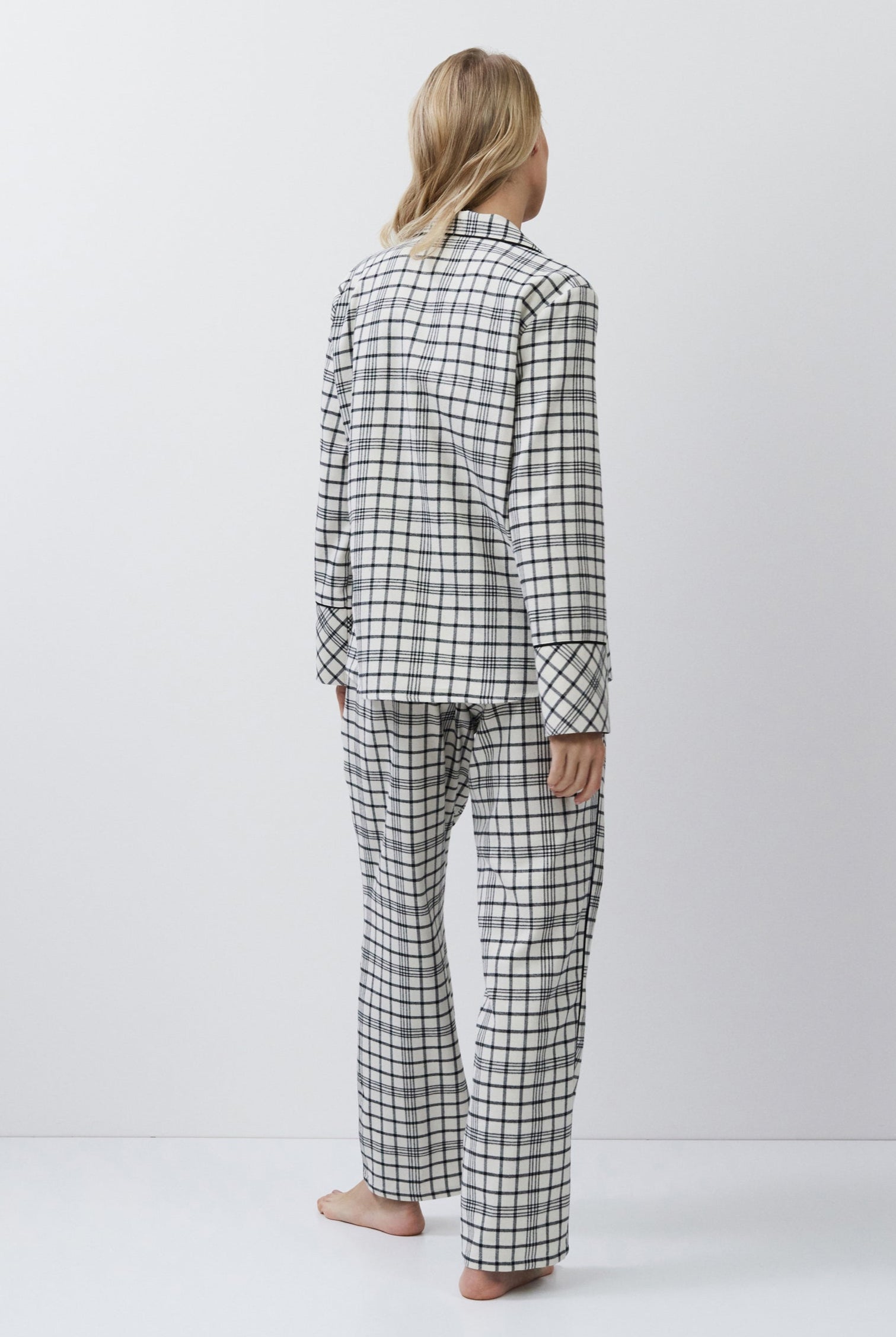 Person wearing a checkered pajama set on a white background