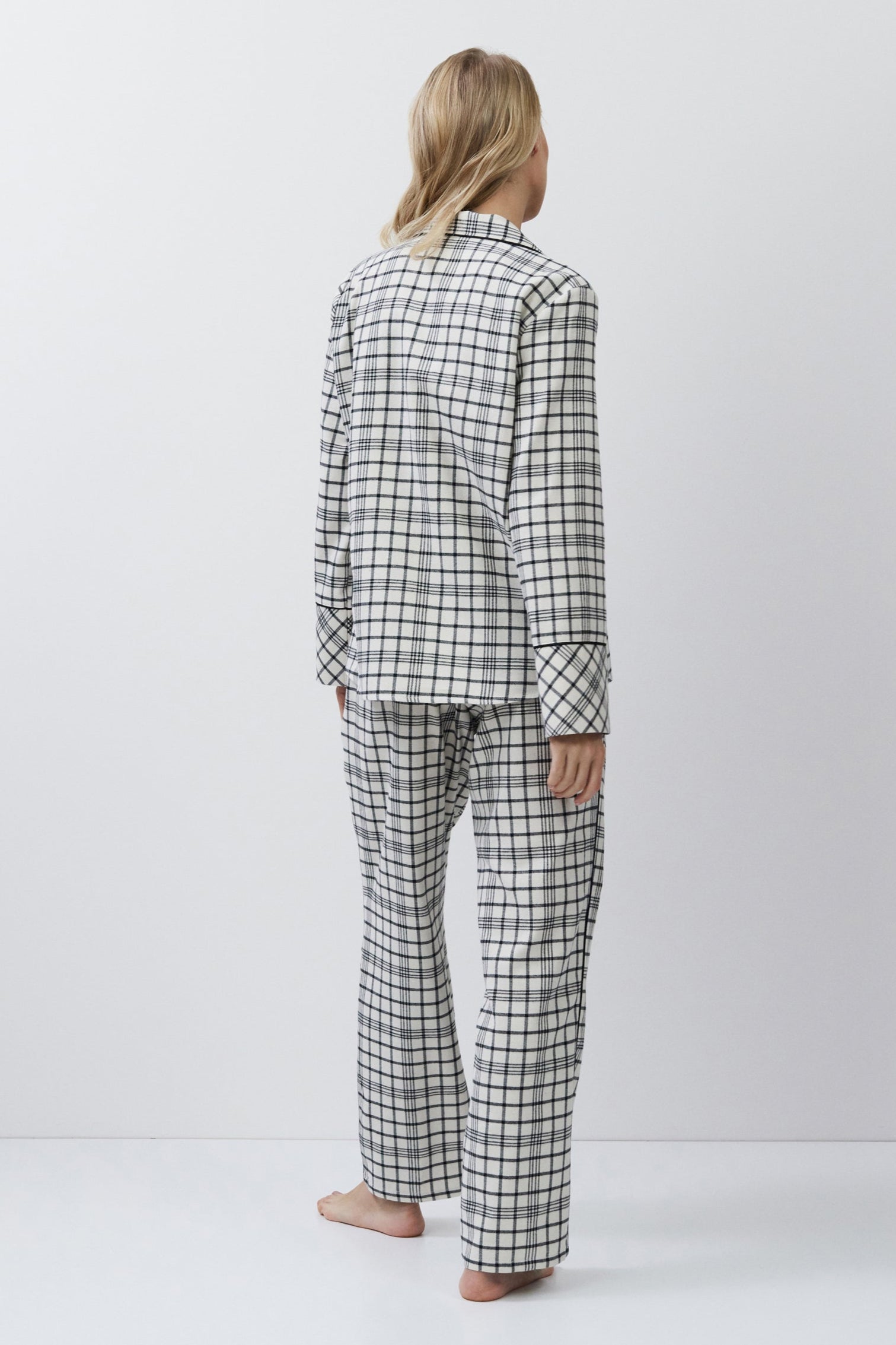 Person wearing a checkered pajama set on a white background