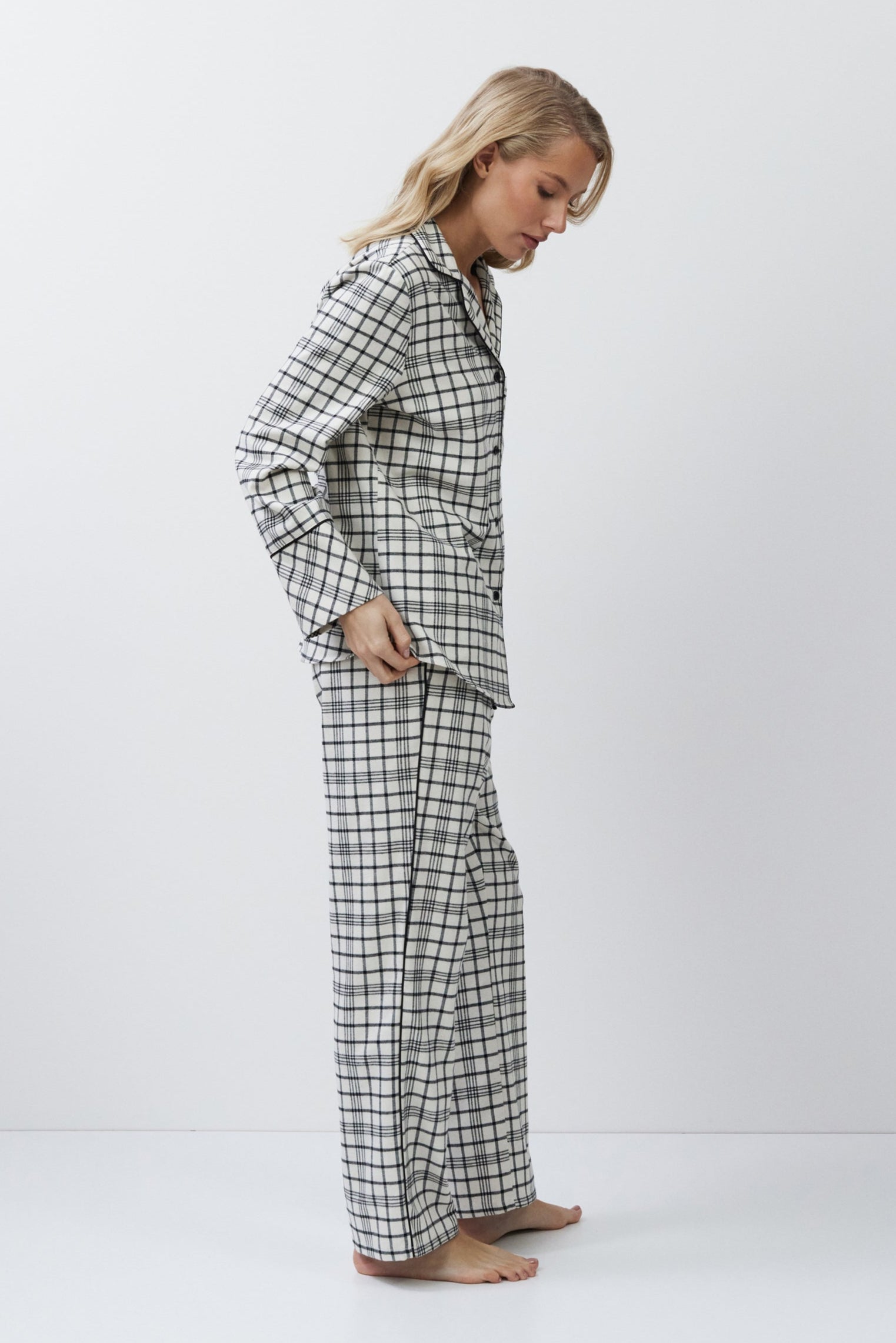 Woman wearing a checkered pajama set on a white background