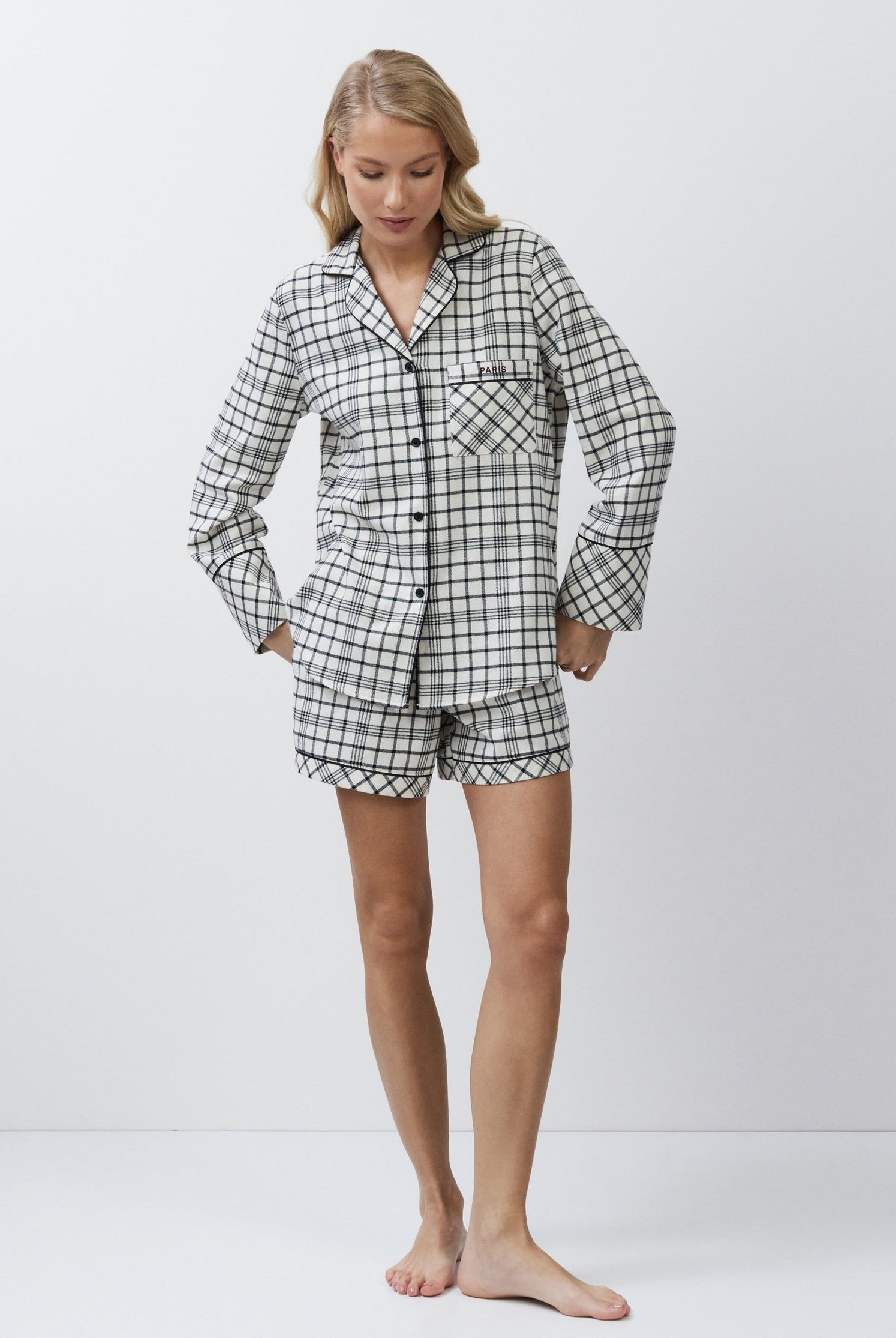 Person wearing a checkered pajama set on a white background