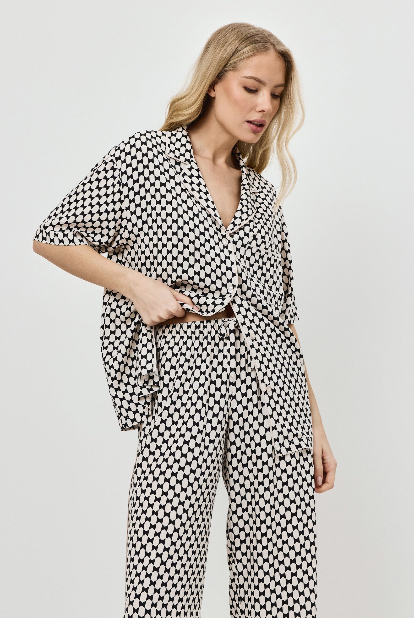 Woman wearing a patterned pajama set on a plain background