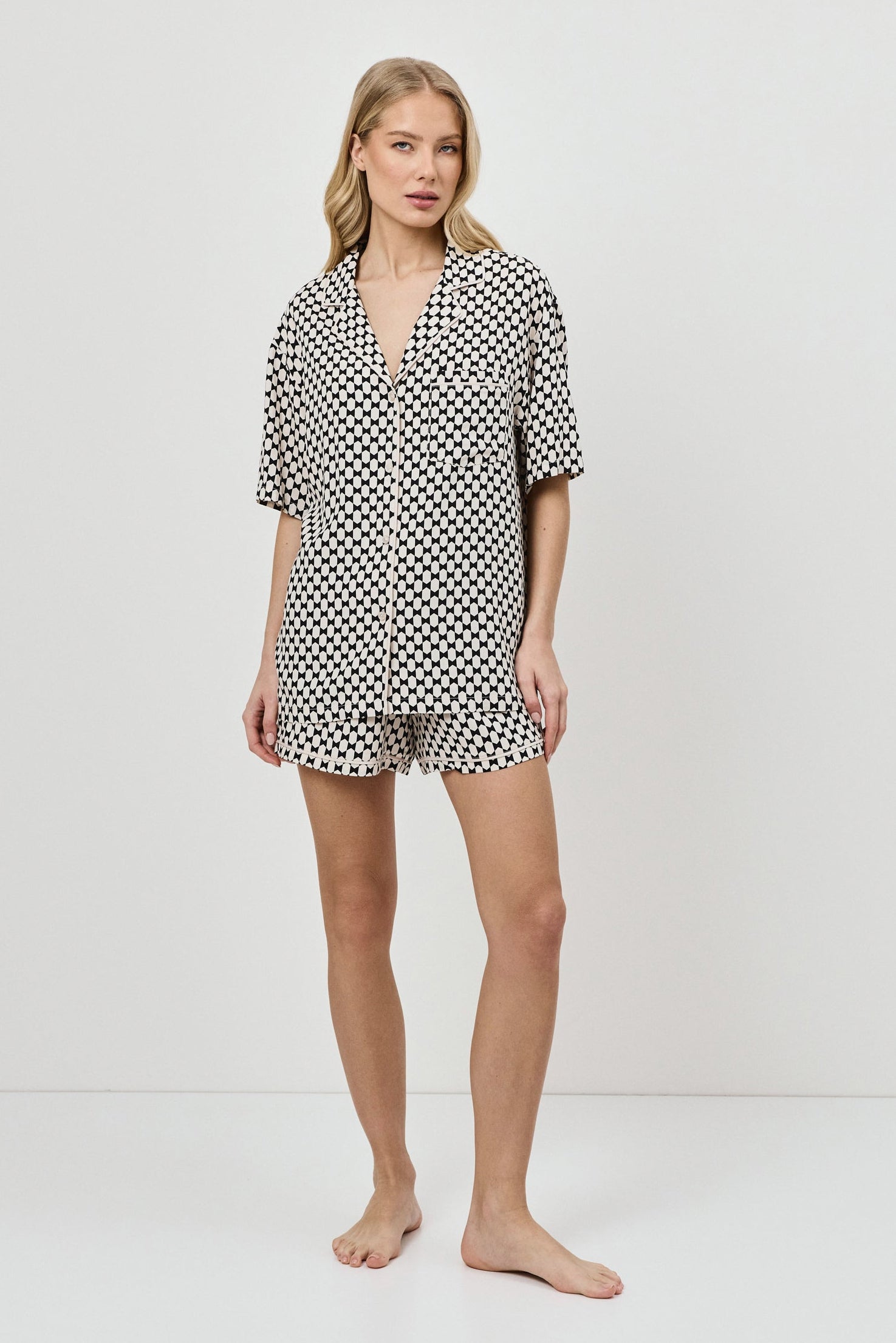 Woman wearing a patterned pajama set on a white background