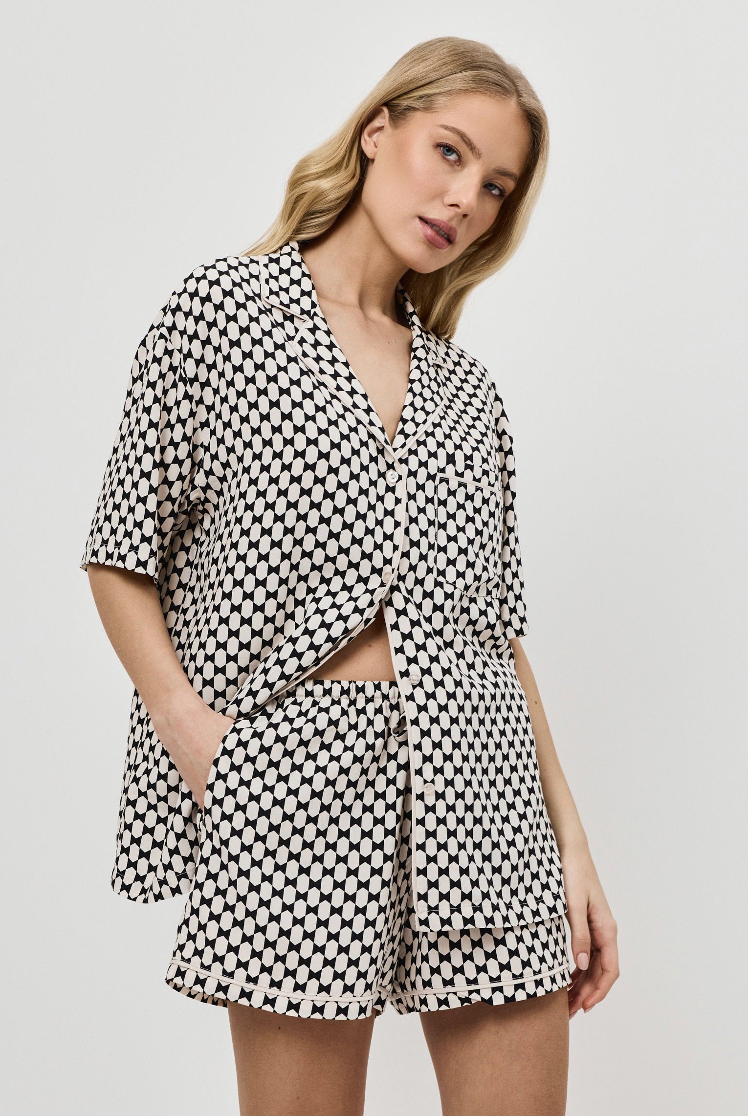 Woman wearing a patterned pajama set on a plain background