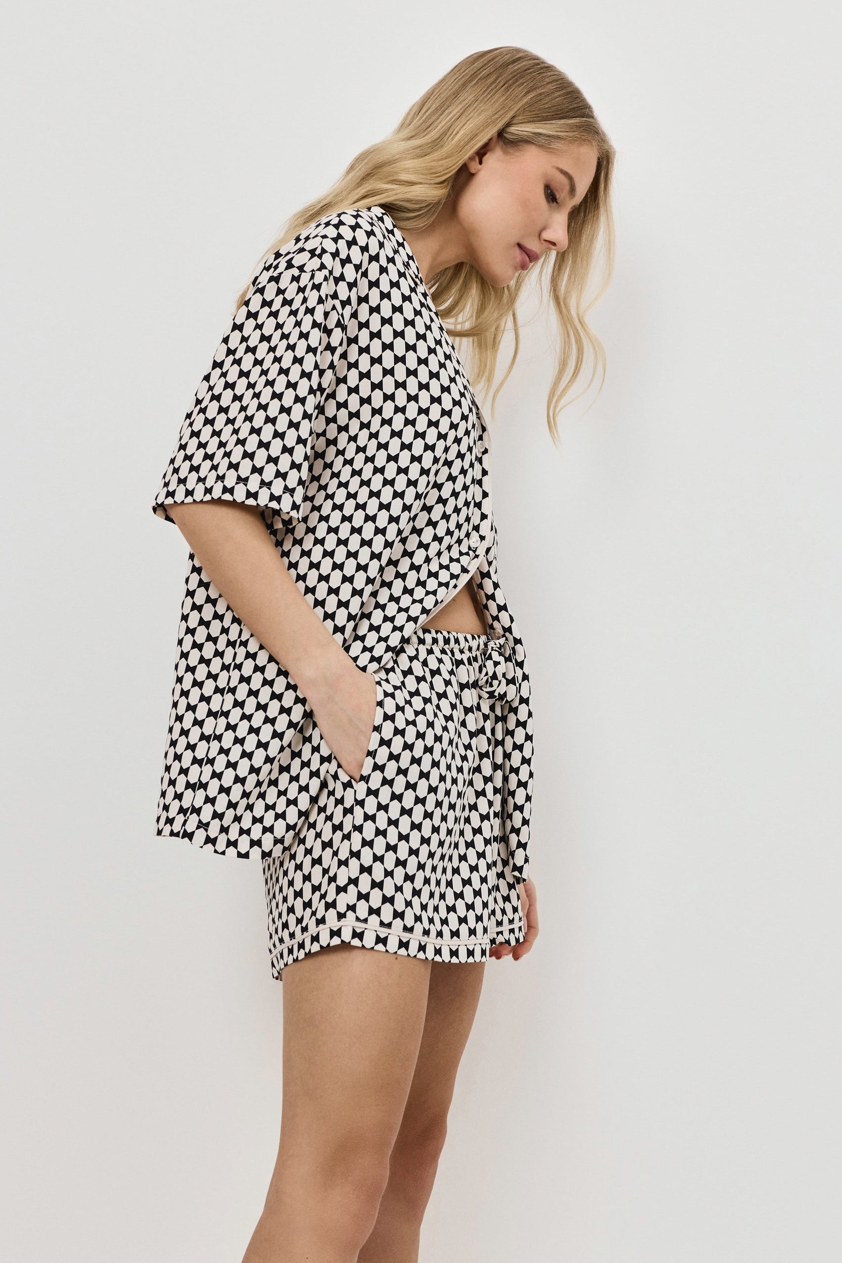 Woman wearing a patterned pajama set on a plain background