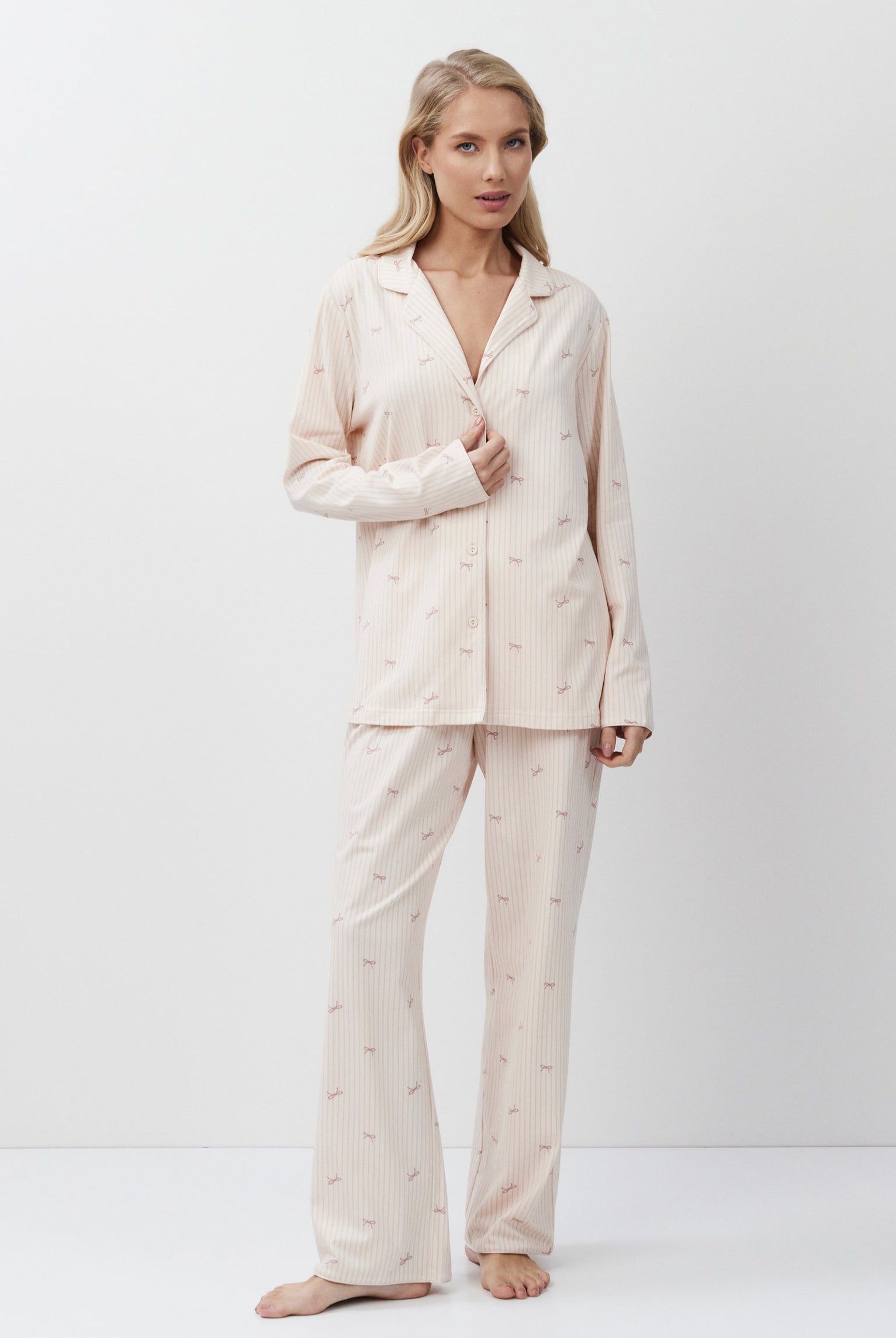 Woman wearing a pink-colored pajama set on a white background