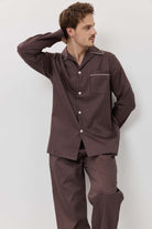 Man wearing a brown checkered pajama set against a white background