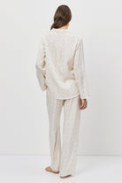 Person wearing a white pajama set standing against a plain white background